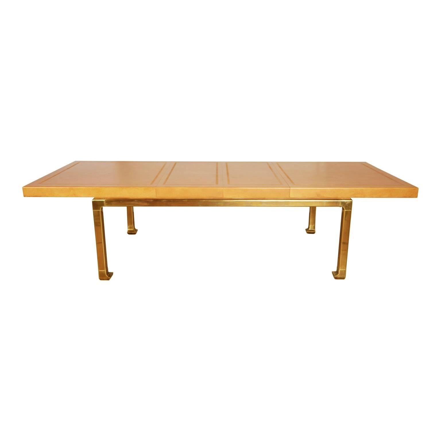 Extraordinary custom-made expandable table from Mastercraft that is just shy of 10ft at its widest. This exceptional piece features a lacquered faux ostrich skin top over wood with embossed patterned border and sturdy luminescent on-trend brass