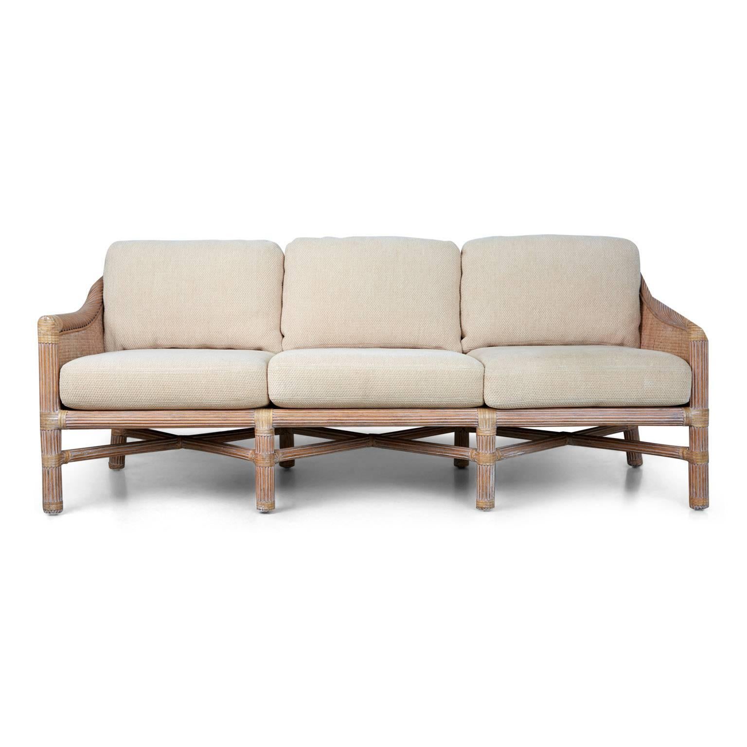 Elegant set of wicker McGuire furniture that can be used indoor or out, which includes one (1) three seat sofa, (1) side table and (1) coffee table. The seats and frame of the sofa are fabricated fabricated from woven rattan and bamboo that has been