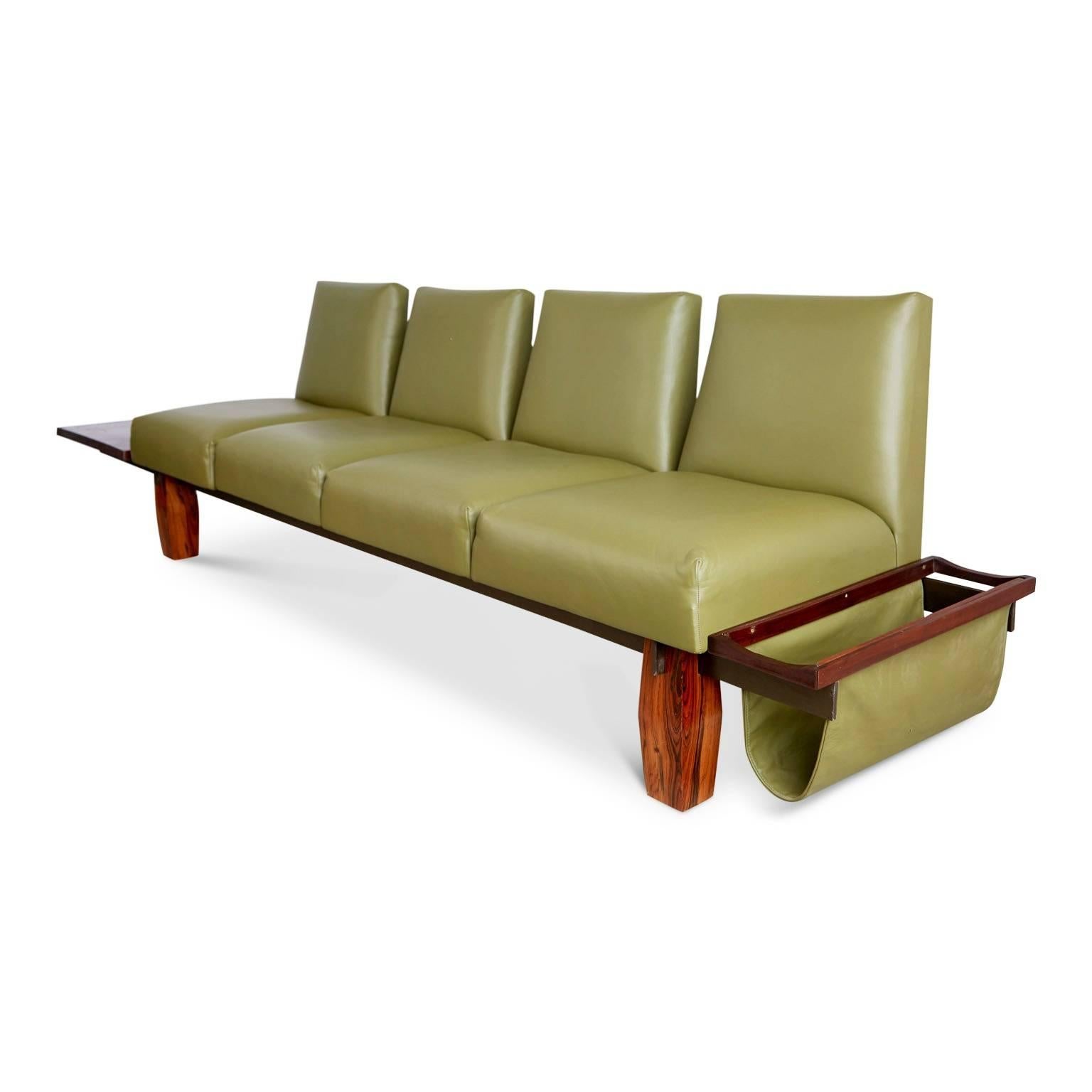 Wonderful example of one of Jorge Zalszupin's designs for the Brazilian manufacturer L'Atelier. This sofa features a Brazilian rosewood frame with a floating side table at one end and a sling magazine rack the other fabricated from the same muted