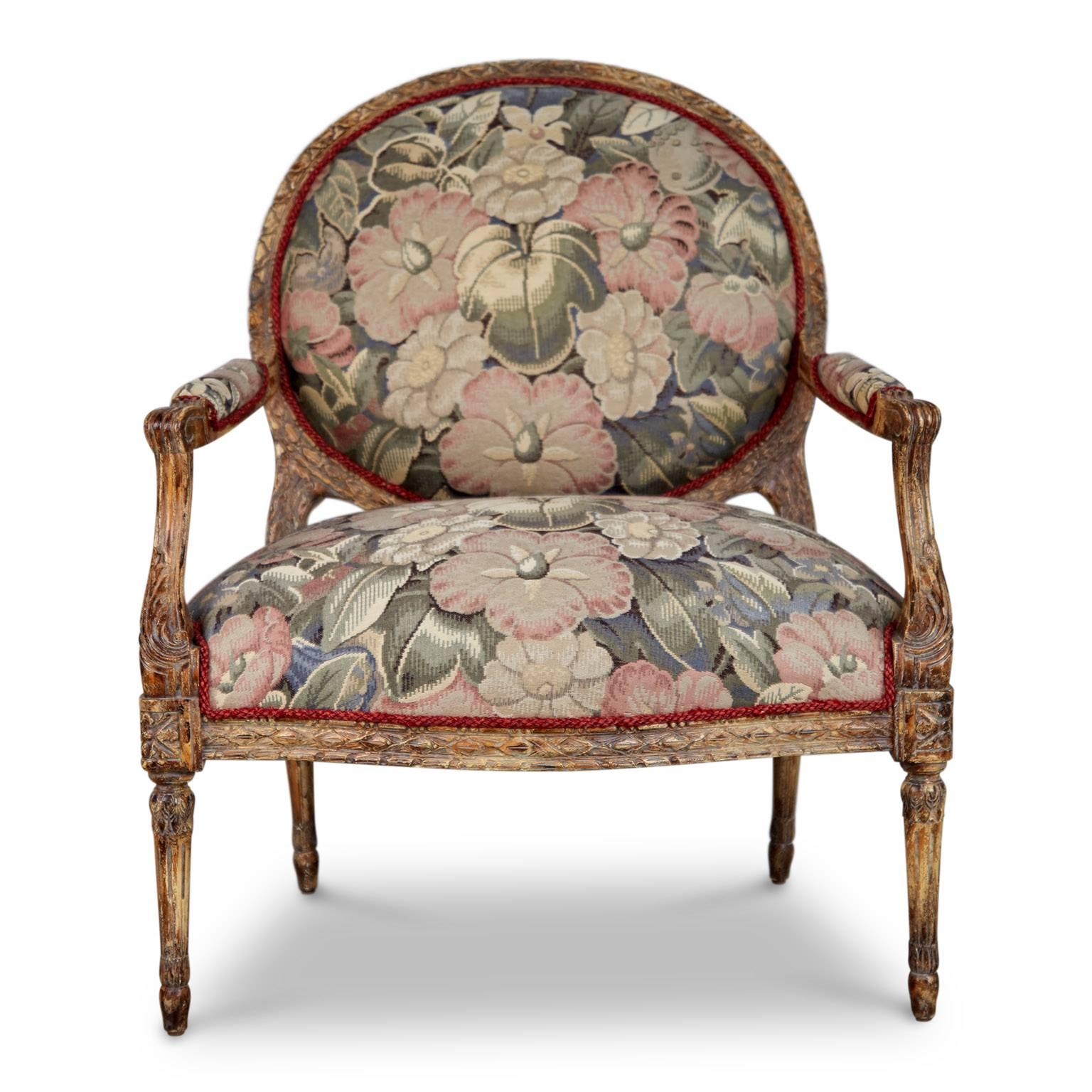 Add a touch of elegance to your surroundings with this pair of high quality Louis XVI style armchairs. Featuring a generously wide seat and carved faux distressed finish wood frame with details on the cresting, stiles, handhold arm, arm support,
