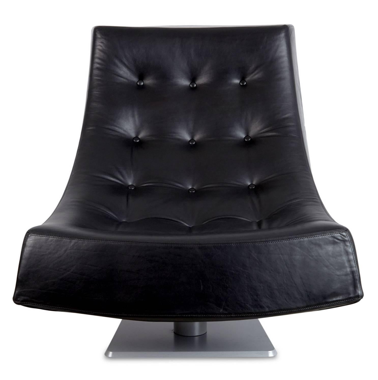 Generously proportioned tufted black leather scoop style lounge chairs. These armless chairs have a semi-swivel mechanism, perfect for diverting your conversation focus from a comfortable seated position. The gentle curve of these laid back chairs