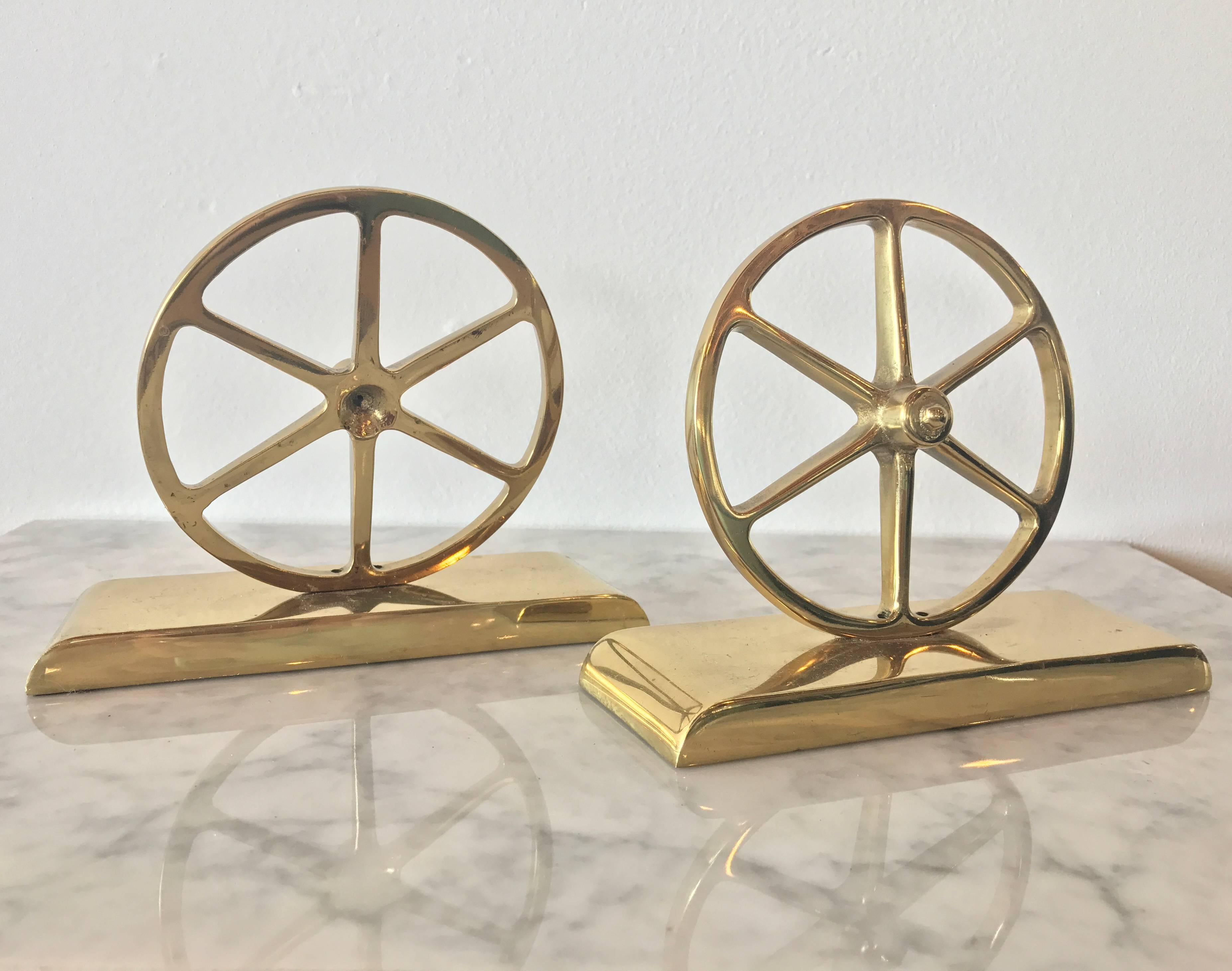 Lustrous pair of wagon wheel bookends in gleaming brass by Virginia Metalcrafters. The underneath is the stamped VM logo and are numbered.

These beautiful on-trend pieces would make a great interior accent to any space. The glowing gold tone