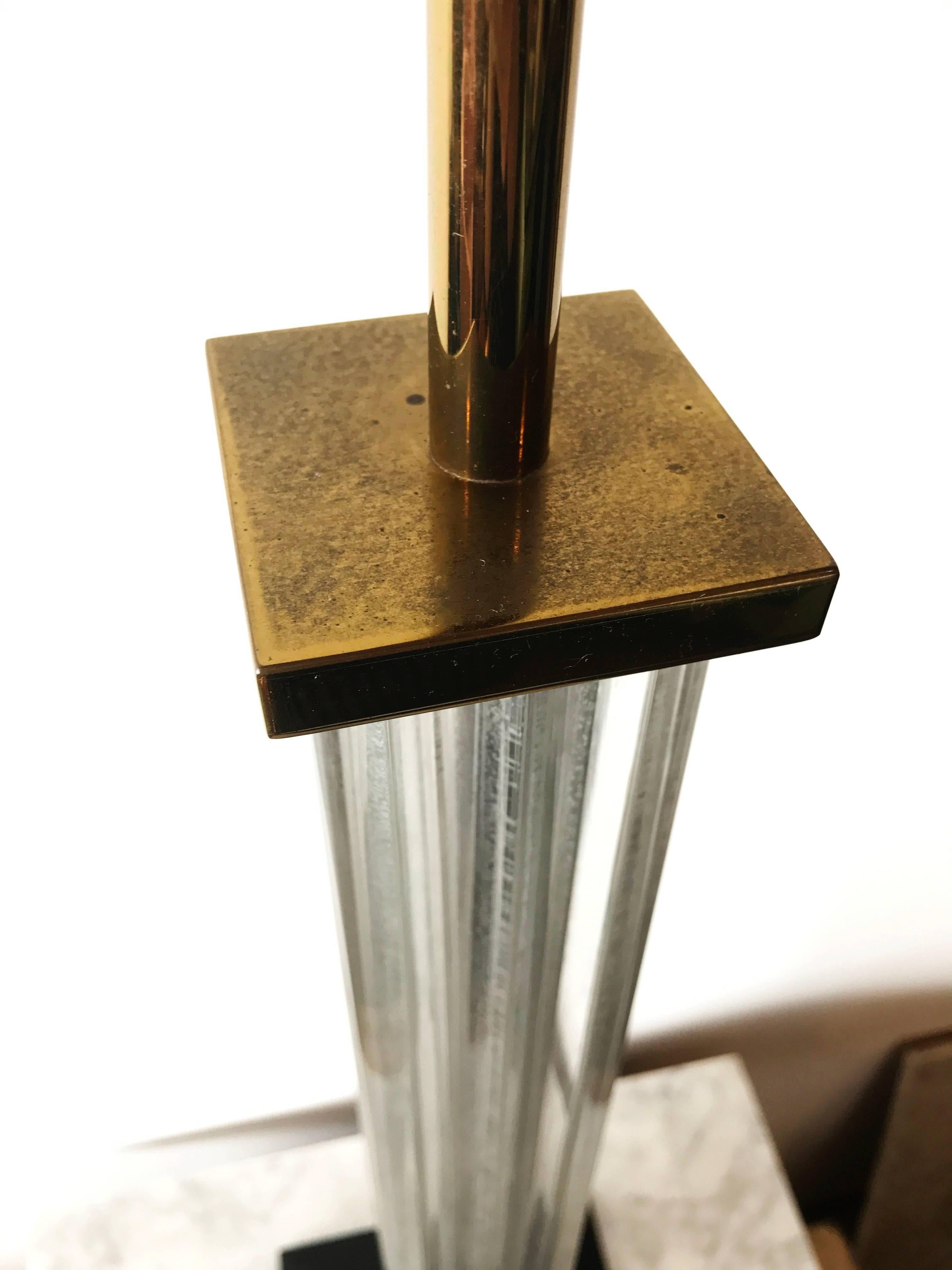 Get your hands on some highly coveted Lucite, one of the current top trends with this tall and slender table lamp. The simple clean lines and brass accents make this piece highly adaptable to fit into a number of spaces whether it be Art Deco,