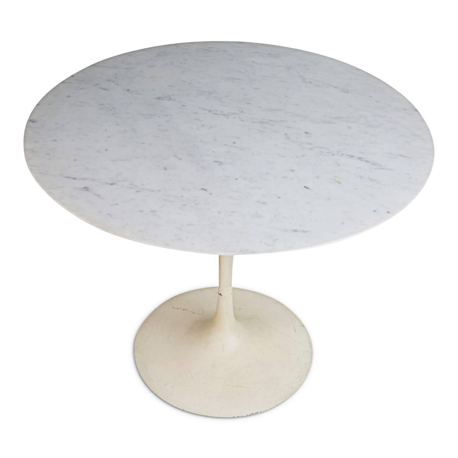 One of the most highly coveted vintage-designer items at present, this elegant marble top dining table designed by Eero Saarinen for Knoll features a broad circular top of Carrara marble supported by a cast aluminium tulip base finished in white