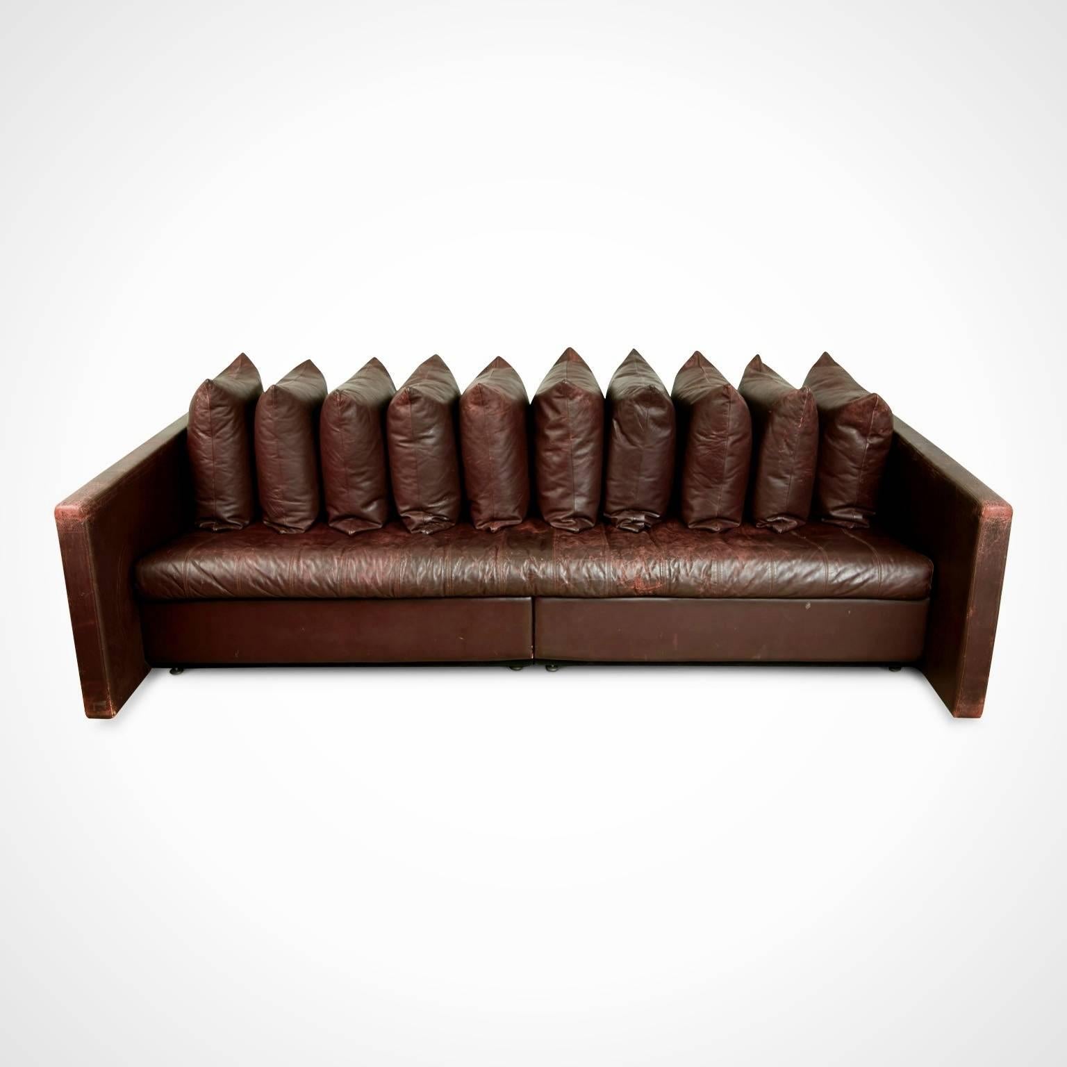 Exquisite ten pillow cushion architectural sofa by Joe D'Urso for Knoll International. Featuring the original deep burgundy cordovan leather upholstery that has built up an admirable patina over time. These traces of age and use bring more vibrancy