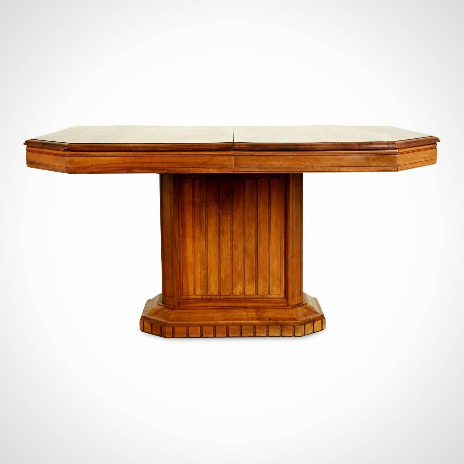 Beautiful French Art Deco dining table or center table fabricated from walnut with beautiful grain. The expansive surface with beveled edge sits atop a sturdy rectangular plinth base with carved channel detail. 

The cleanly executed style of this