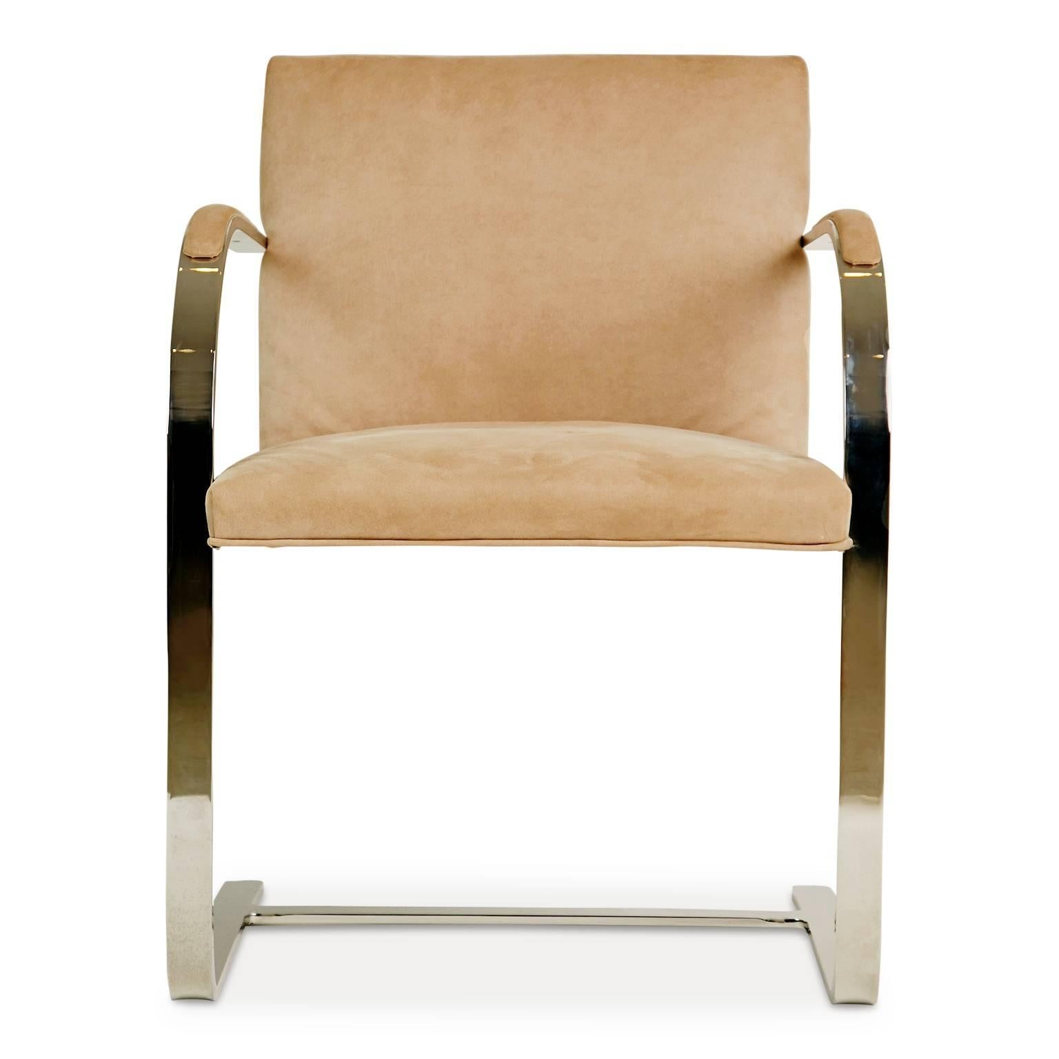 A striking set of six flat-bar armchairs by Brueton featuring sleekly designed chrome cantilever frames which form a graceful arch and are upholstered in a beige ultrasuede with undertones of peach. 

We also have a monumental circular dining