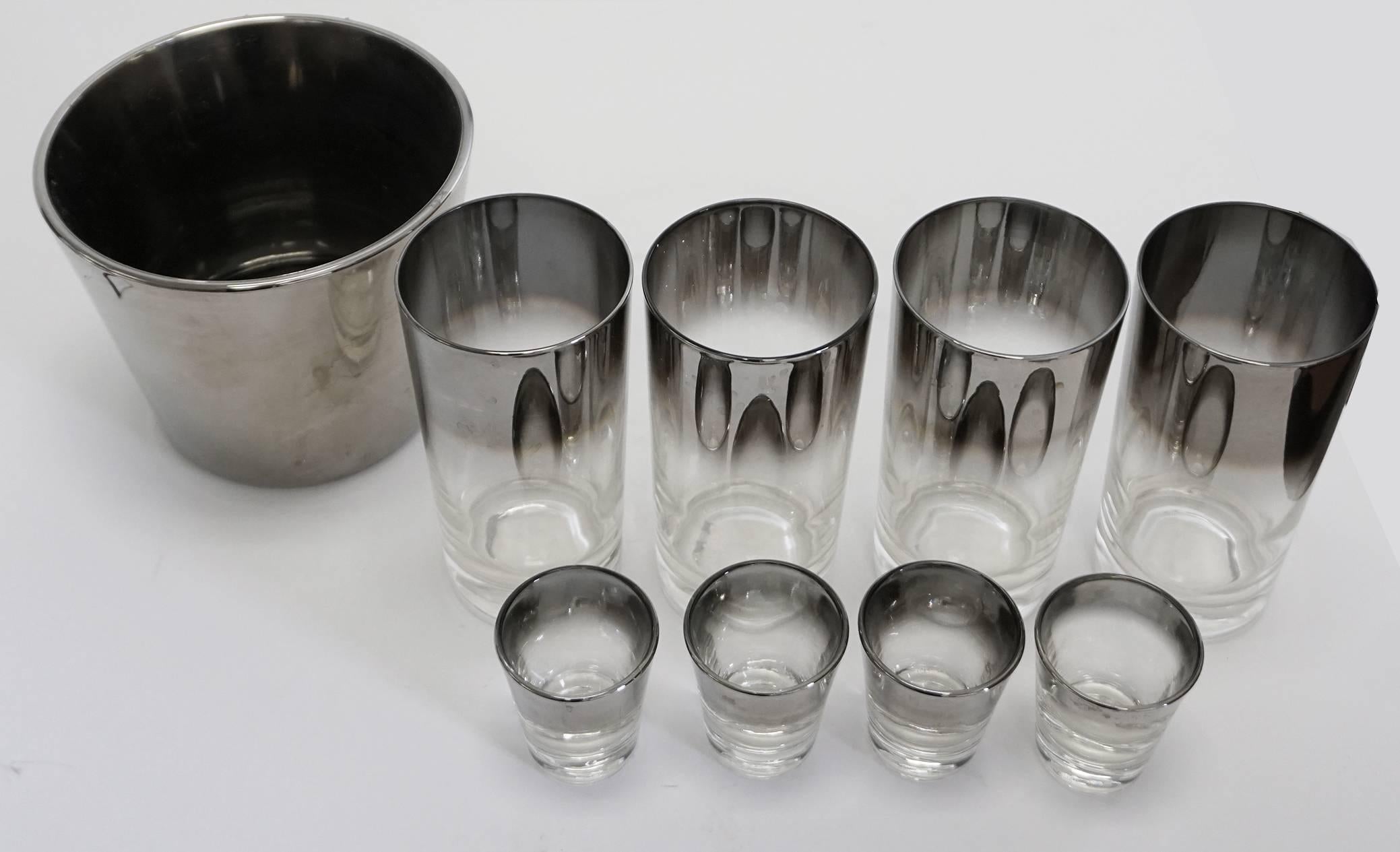 In the manner of Dorothy Thorpe, a set of four silver fade highball tumblers, four shot glasses and ice bucket. Classic bar essentials! Sizes: Highballs: 2 3/4" W x 2 1/4" D x 5 1/2 T. Shot glasses: 2" W x 1 3/8" D x 2 3/8 T. Ice