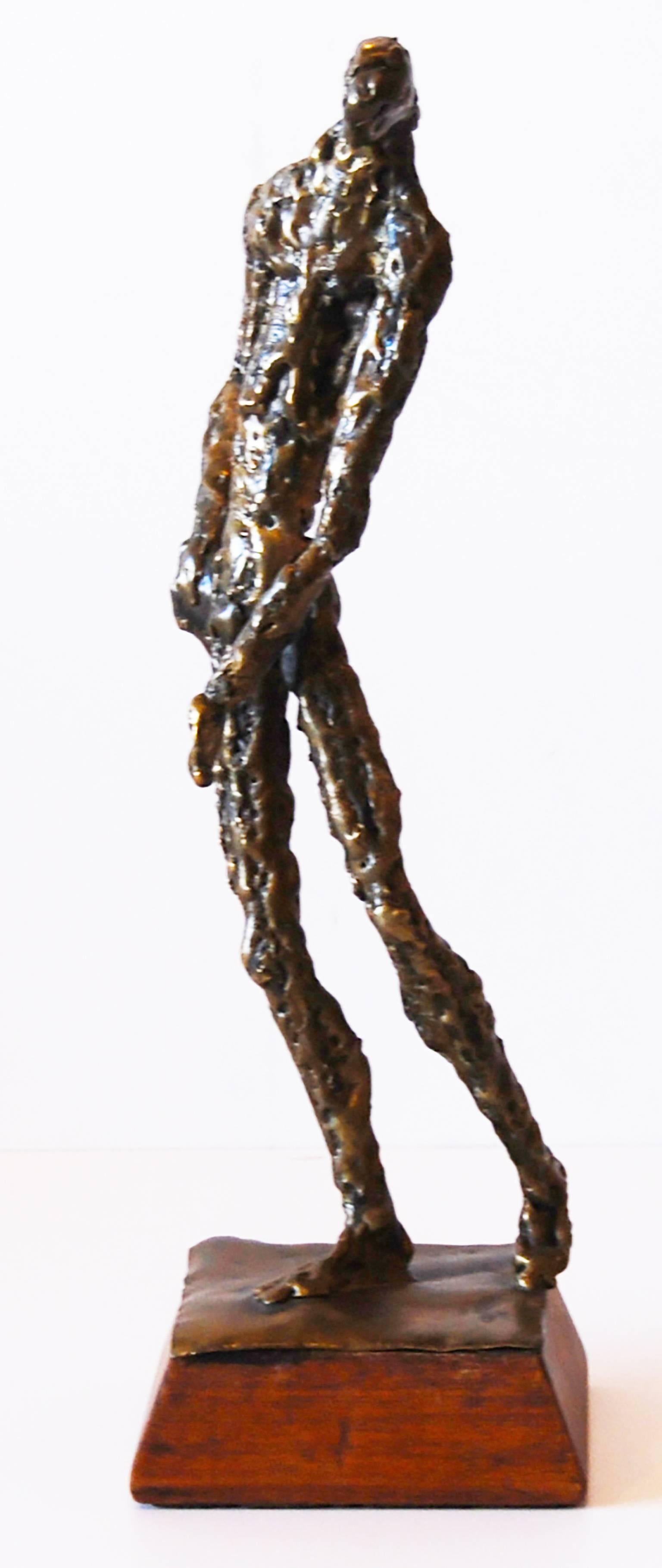 Giacometti style sculpture on a wood base.