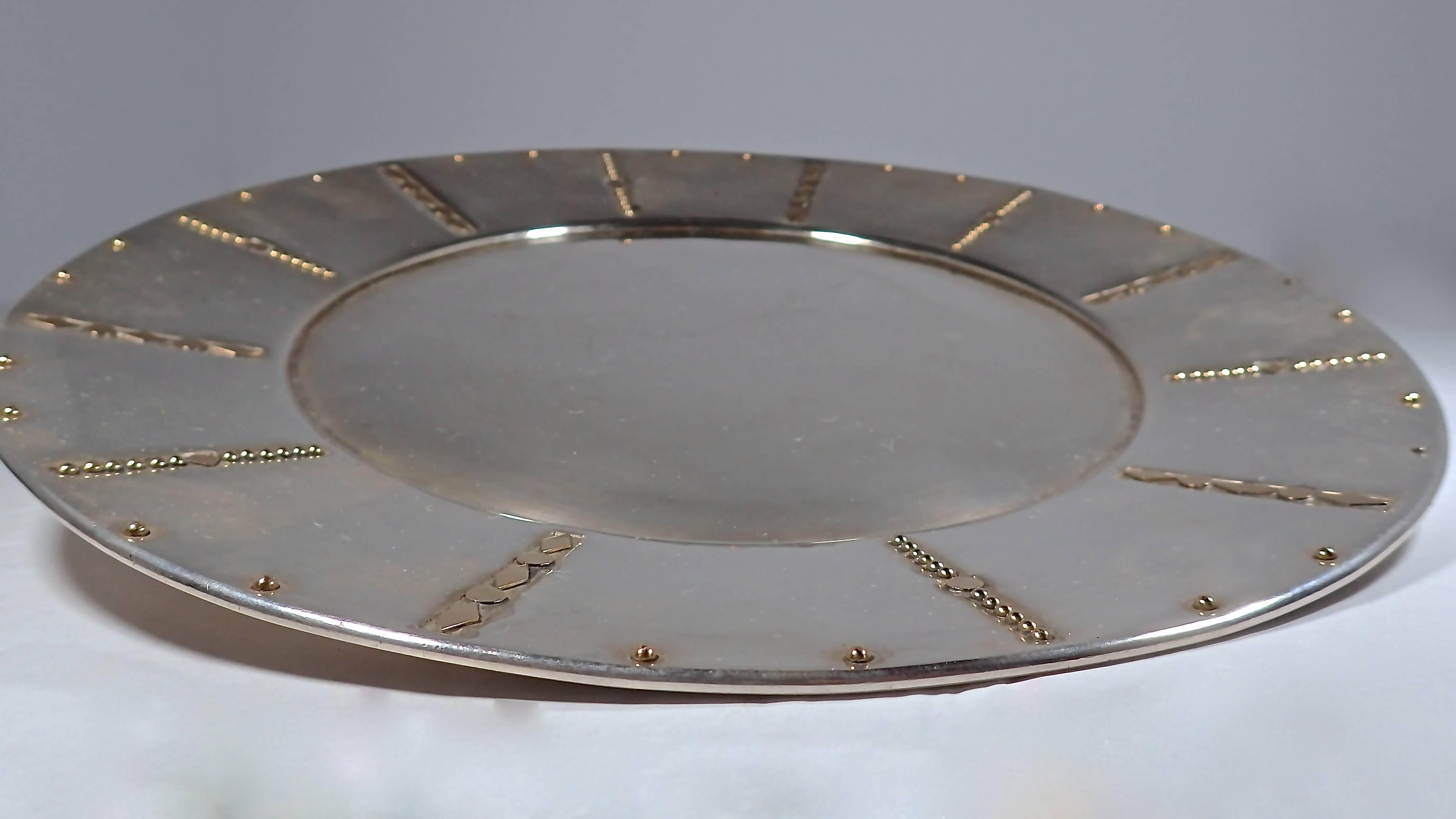 Simple sterling silver plate with inlayed brass details in and along the border. Stamped with Spratling's silver mark: Eagle with 30 (for authenticity).  