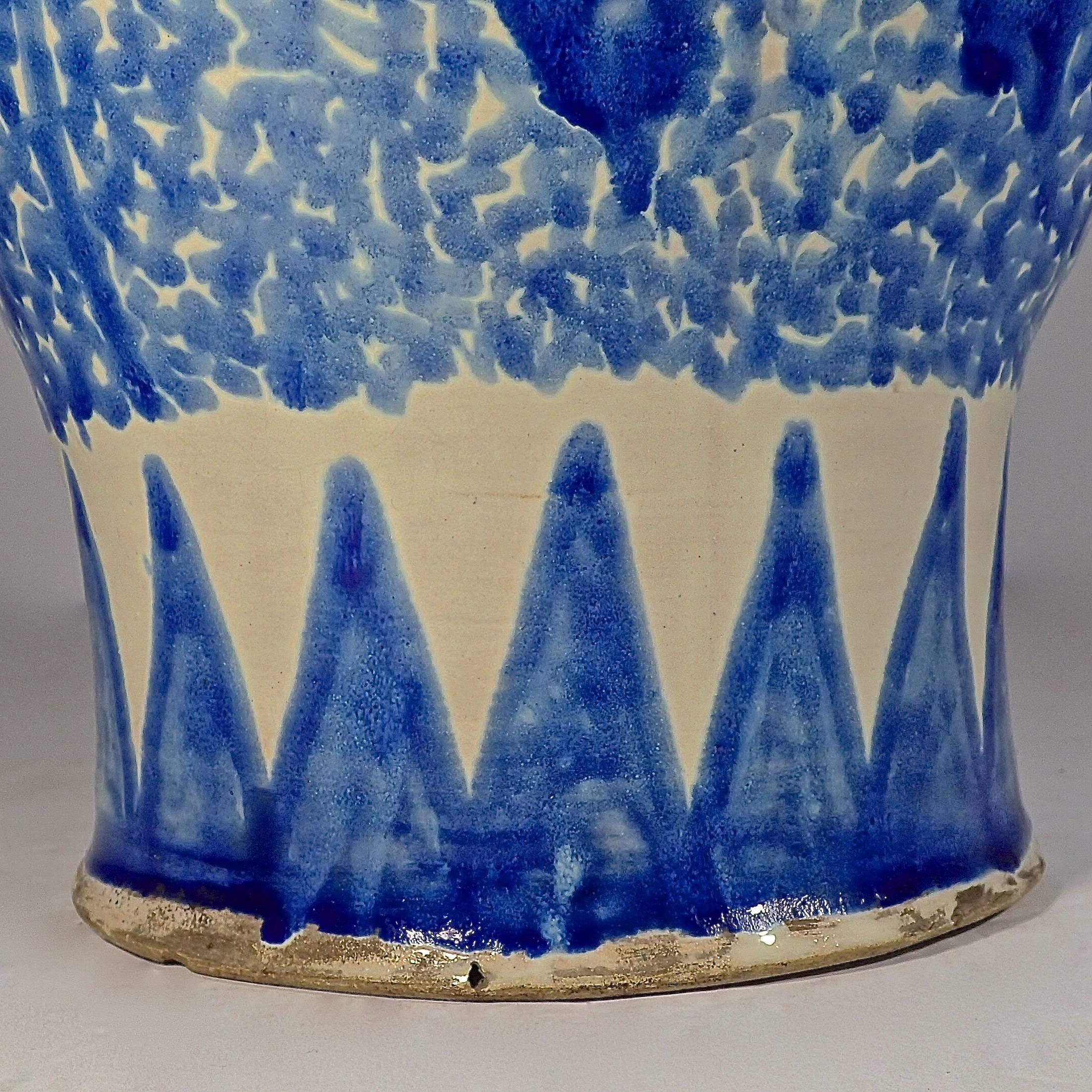 Decorative blue-washed glazed jar with painted floral motifs and repeating border. 
No signature