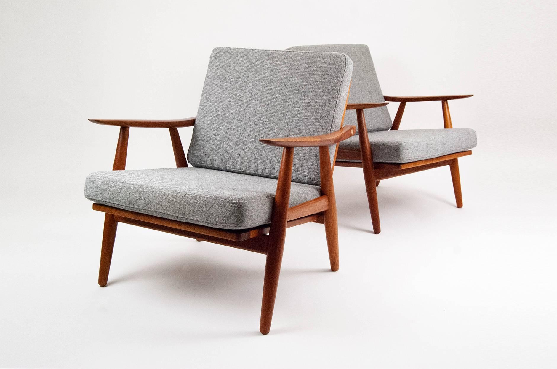 Rare GE-270 lounge chairs, designed in 1956 by Danish icon Hans Wegner. Produced by GETAMA Gedsted, Denmark. Restored teak frames with exposed brass fixtures. New cushions covered in Kvadrat Hallingdal 130 fabric.