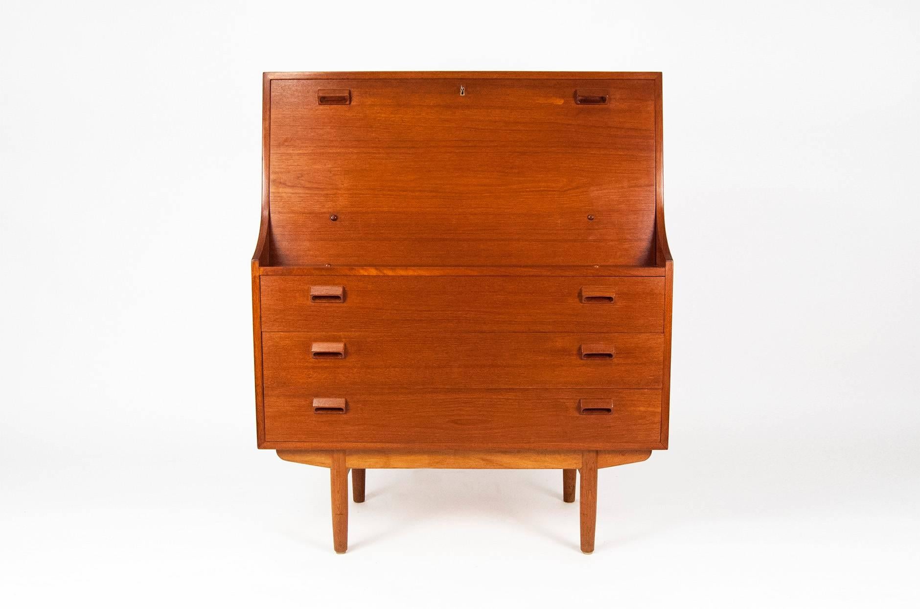 Teak bureau, circa 1960s. Produced by Soborg Møbelfabrik, Denmark. Teak body with three drawers on oak frame. Flip down writing desk and internal drawers. Comes with original key.
 