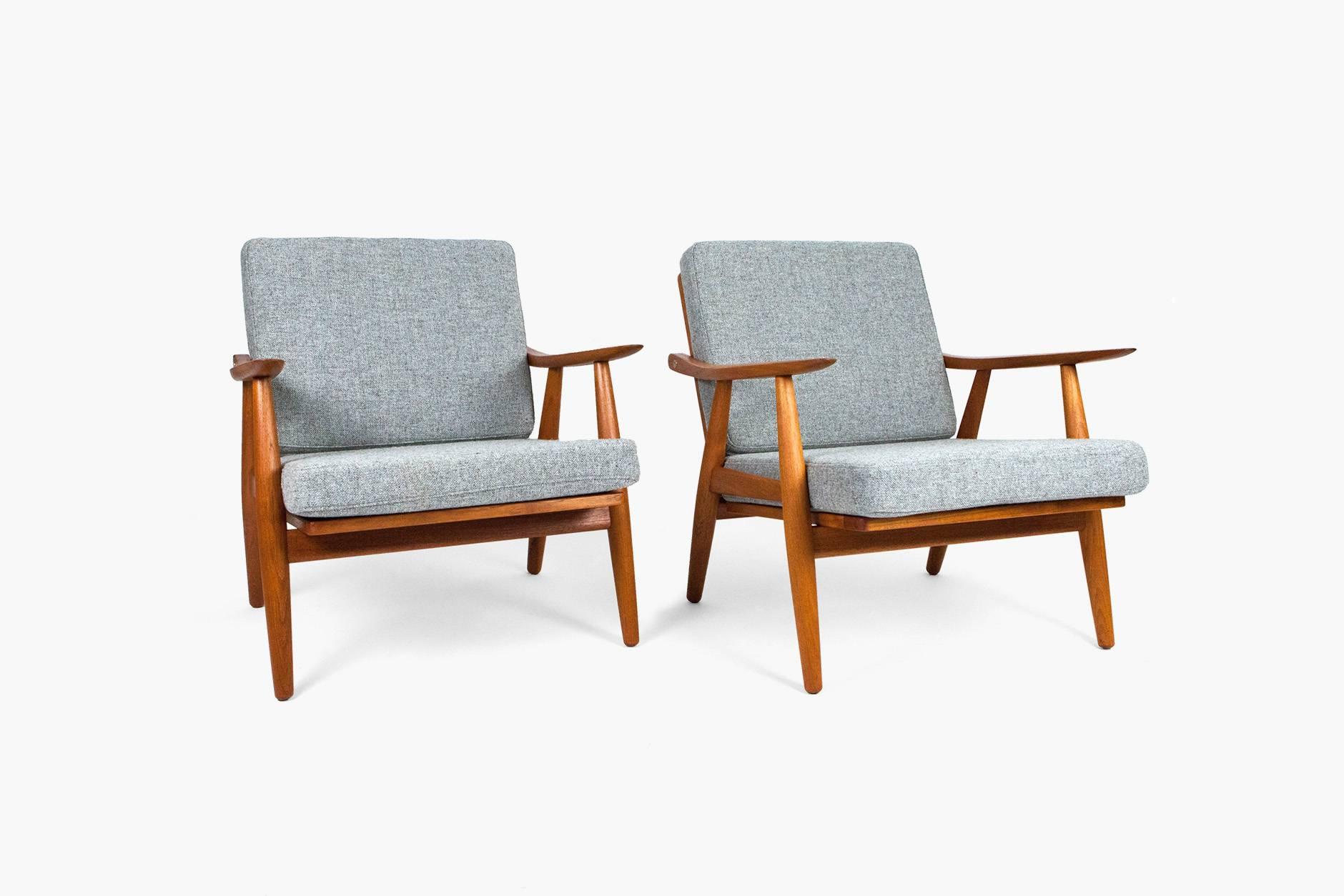 Hans J. Wegner GE-270 lounge chairs, 1956. Produced by Getama Gedsted, Denmark. Restored teak frames with exposed brass fixtures. New cushions covered in Kvadrat Hallingdal 130 fabric.
 