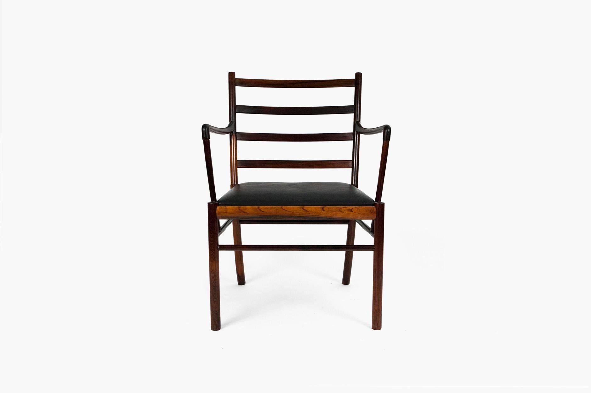 Rarely seen armchair version of the iconic colonial chair in Brazilian rosewood. Seat and loose back cushion covered in original black leather. Manufactured and marked by P. Jeppesen.