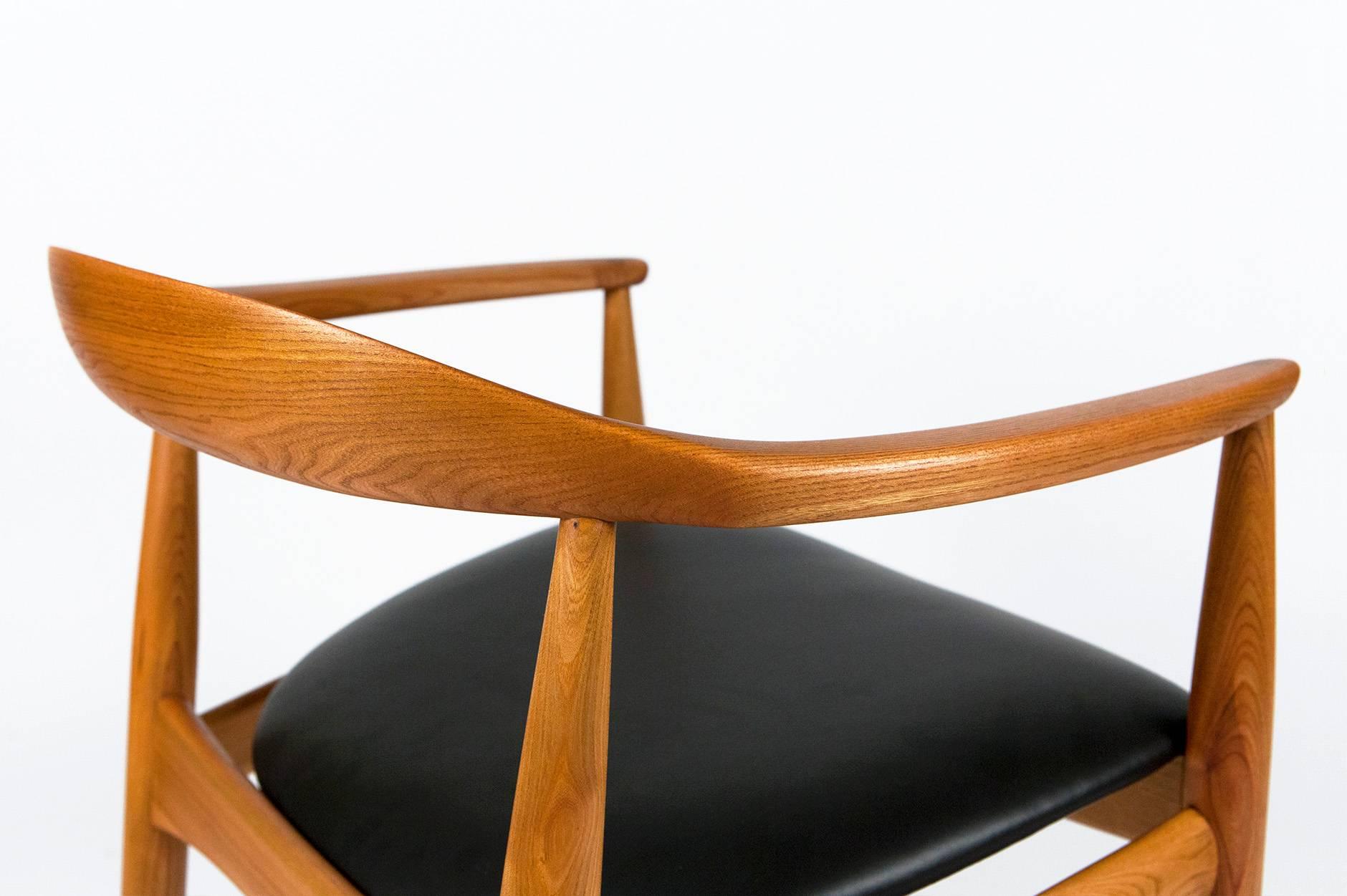 Danish made elmwood round chair produced by Niels Eilersen, circa 1960. Seat reupholstered in new black leather.
