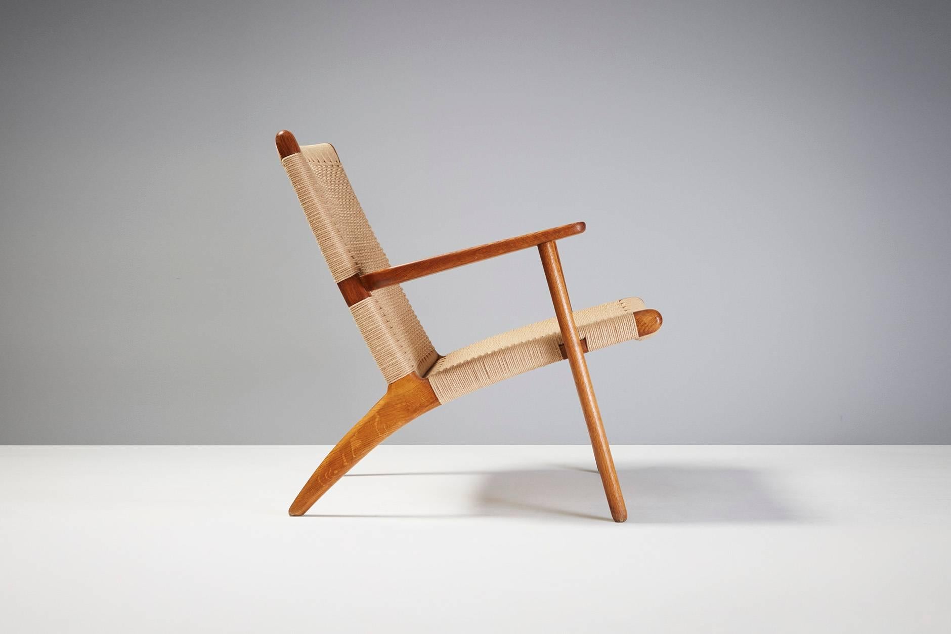 Hans J. Wegner

CH-25 lounge chair, 1950

Produced by Carl Hansen & Son, Copenhagen, Denmark. Oak frame with new woven paper cord seat and back. 

Measures: H 73 cm, Seat: H 35cm x D 73cm x W 71cm.