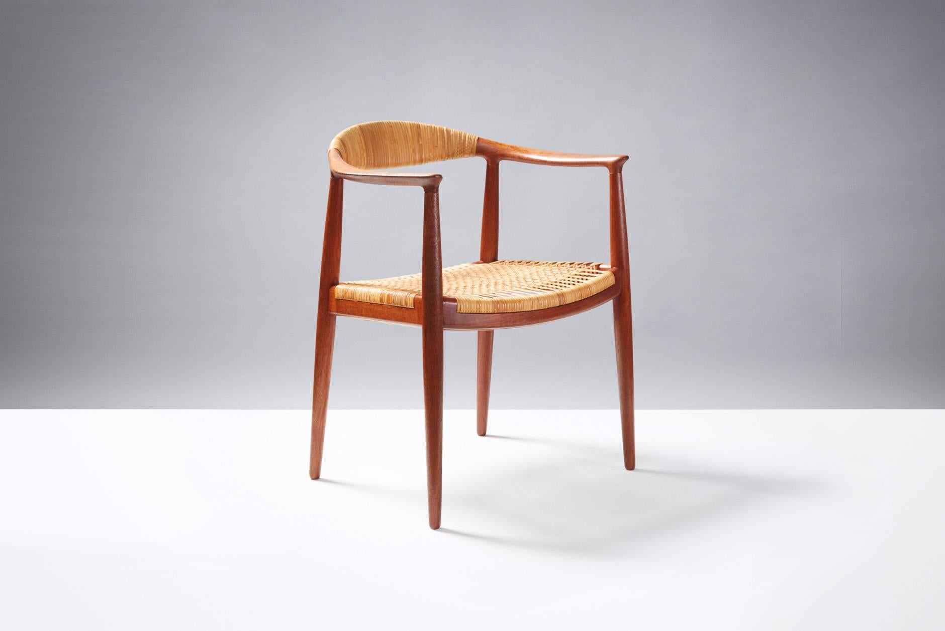Early production of Wegner's most iconic design. Beautifully patinated, aged Burmese teak frame with woven rattan seat and backrest. Later versions were without the rattan wrap on the backrest. Produced by Johannes Hansen, Denmark. Original rattan