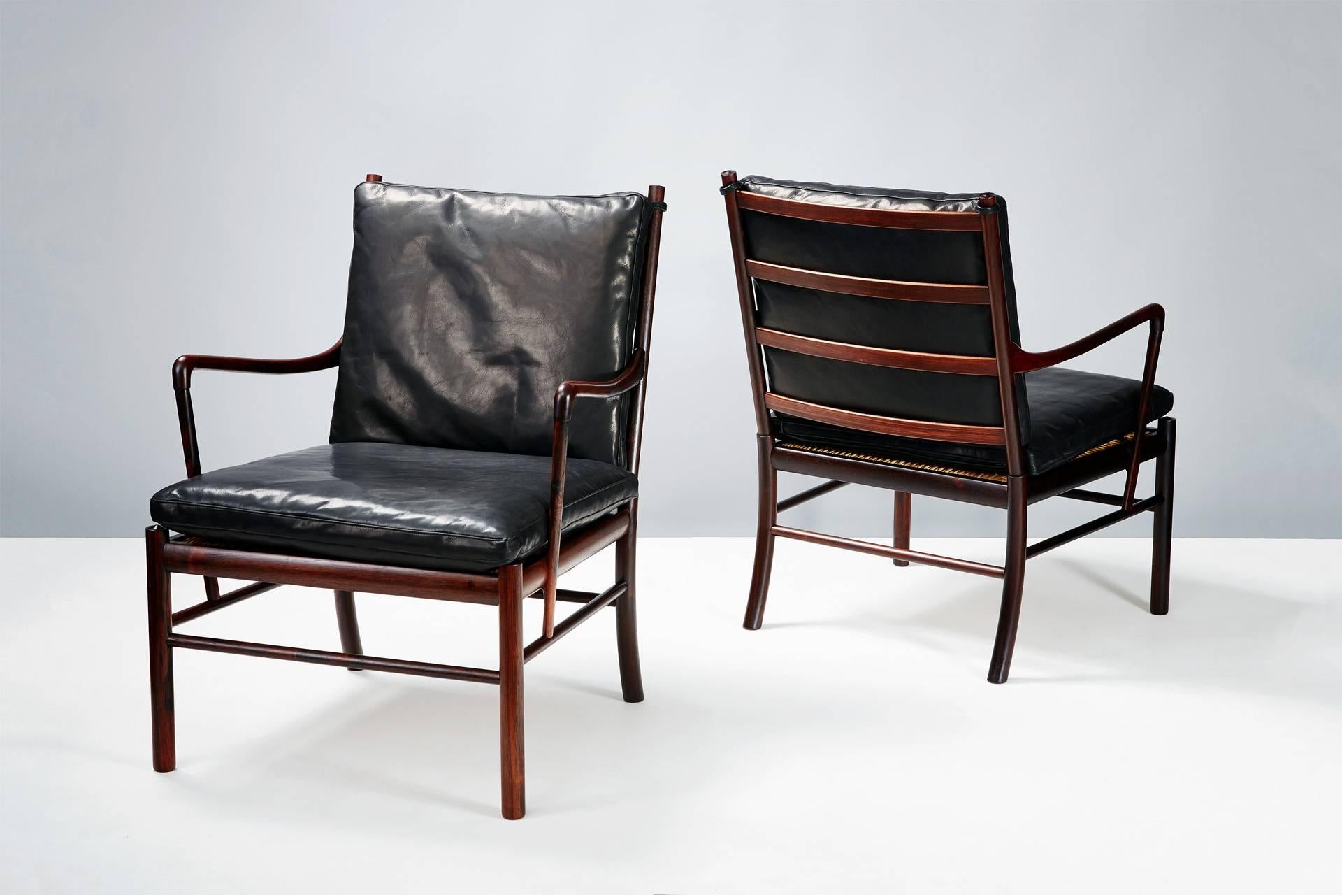 Solid Brazilian rosewood armchairs with woven cane seats. Produced by Poul Jeppesen, Denmark, circa 1960. Black aniline leather seat cushions.