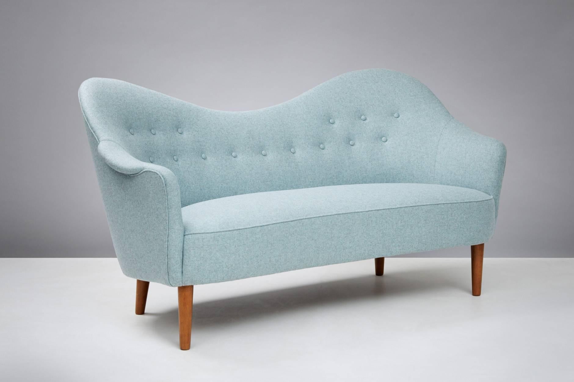First designed in 1956 and produced by AB Record, Bollnas, Sweden. Reupholstered in Melton wool fabric from Abraham Moon. Stained beech legs.
