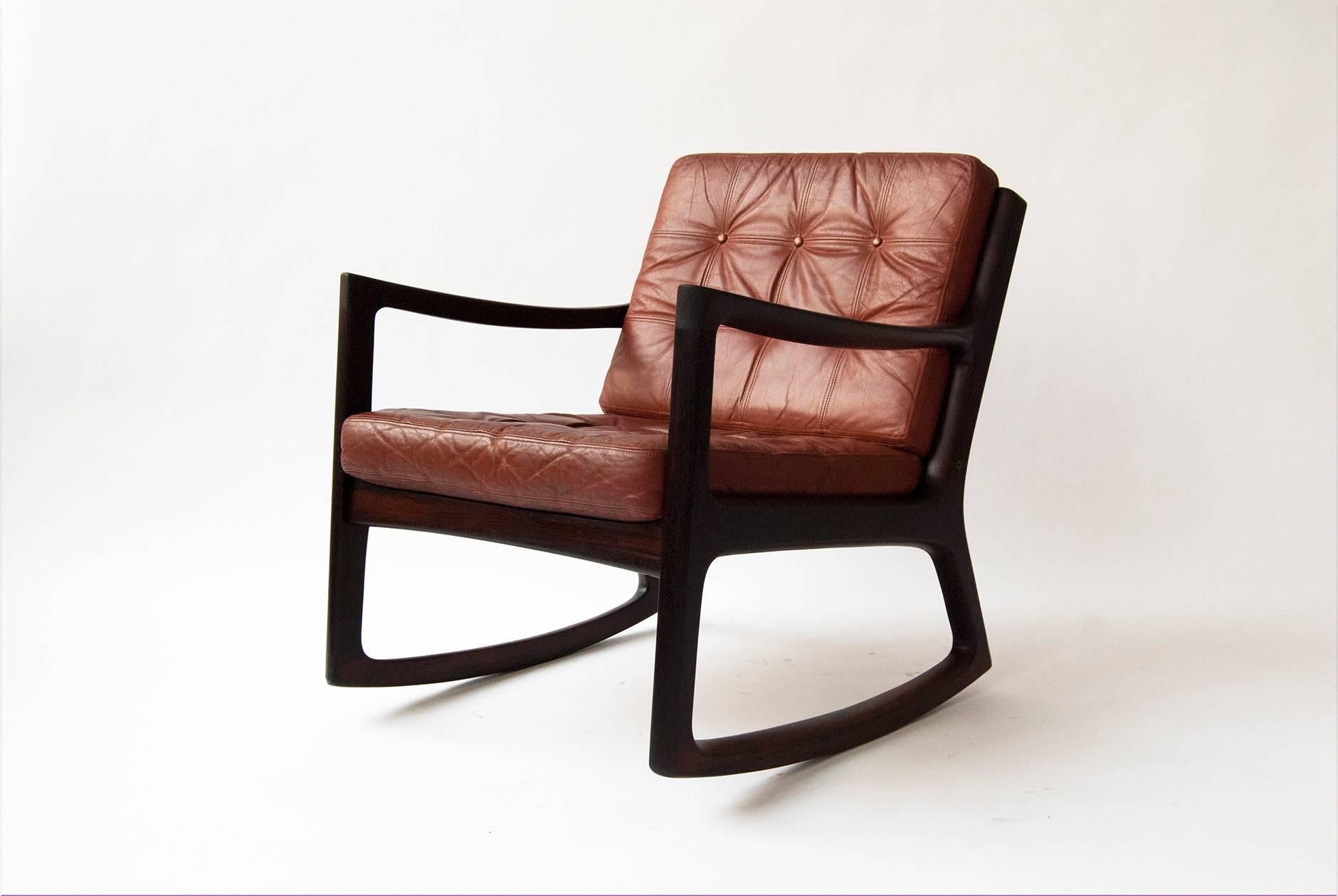 Ole Wanscher 'Senator' rocking chair, circa 1960. Produced by Cado, Denmark. Solid Brazilian rosewood. Includes maker's stamp and production number. Original patinated red leather cushions.