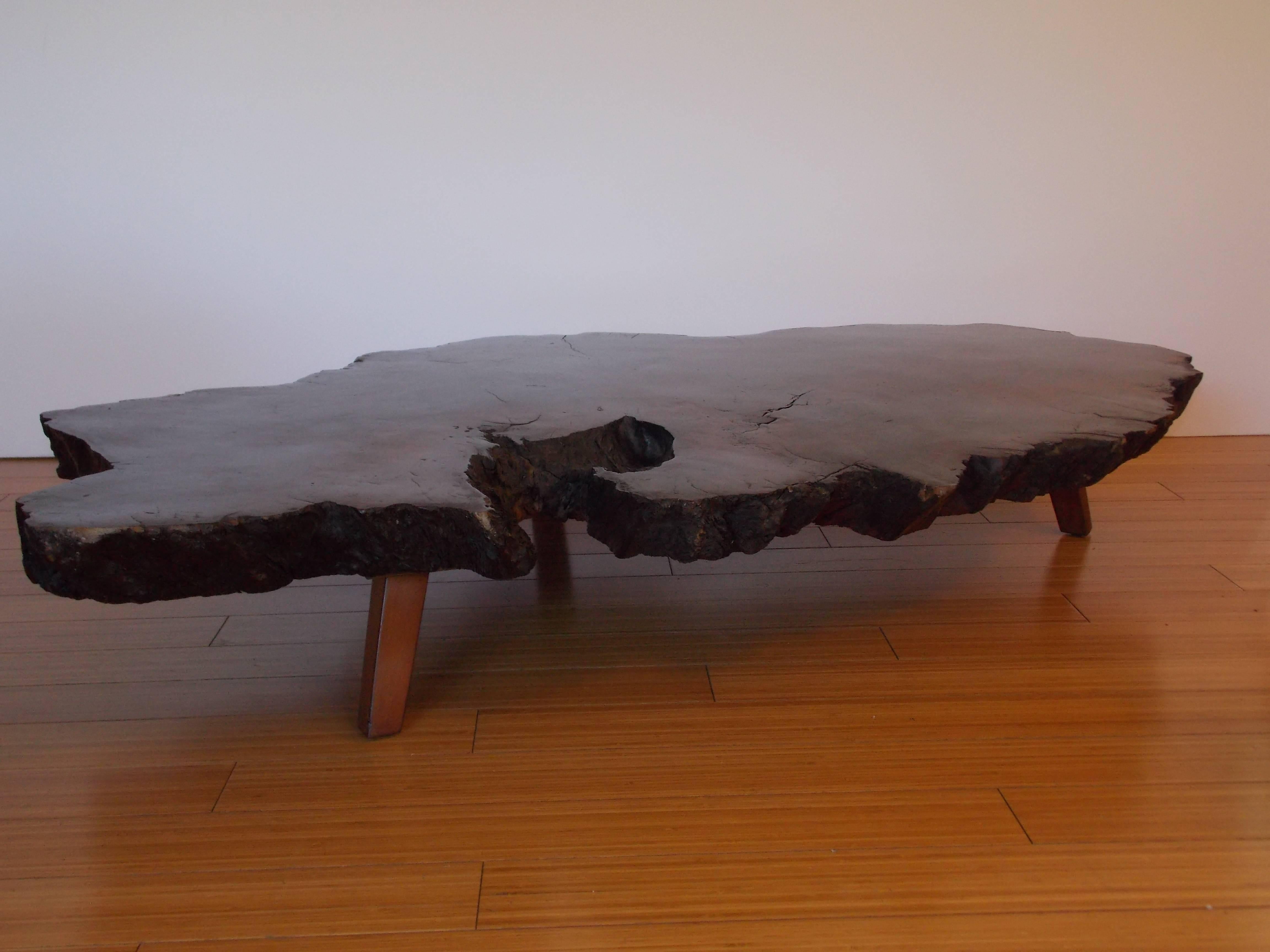 A nice rustic zen design.
It has a nice grain color.
It appears to be burl wood with birch wood legs.
It has not been refinished and is in the original vintage / used condition.
It shows ware with patina consistent with age.
Solid and sturdy.
 