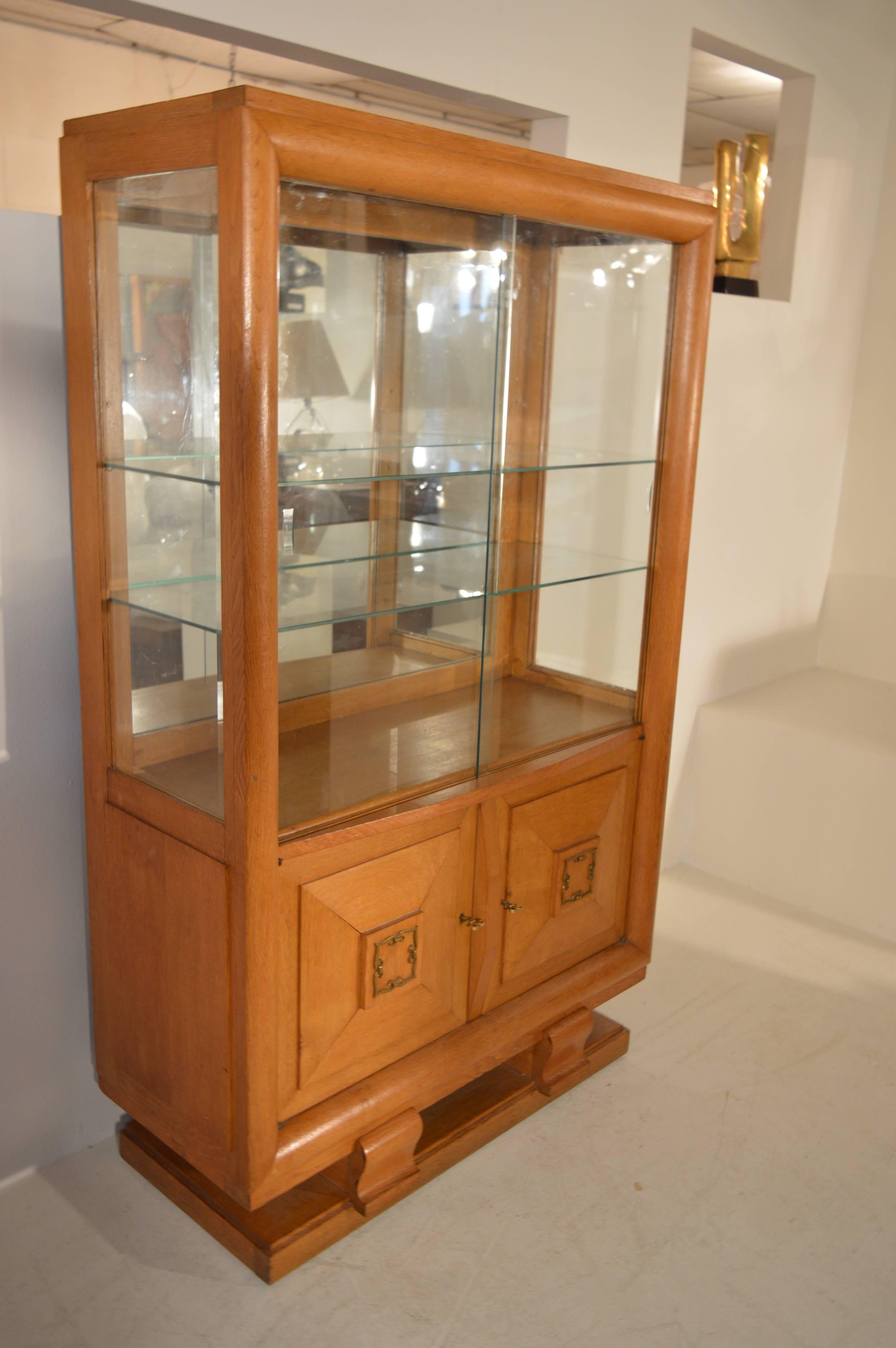 High-quality vitrine cabinet in solid oak, in the style of Charles Moreux.
This vitrine with two glass-sliding doors is in a very good original condition.