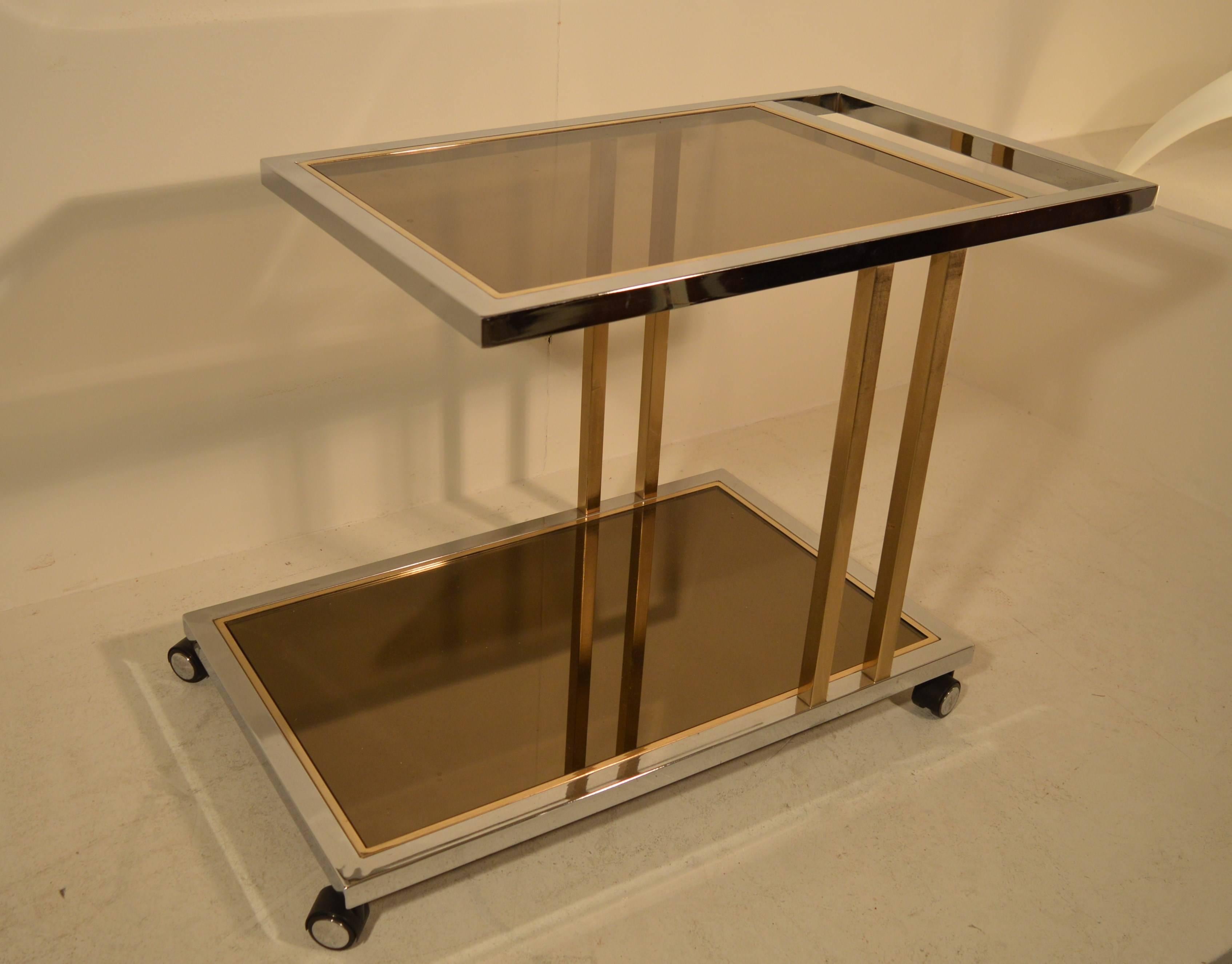 Gold-plated and chrome base, with smoky glass on top and bronze mirror at the base, Asymmetrical two-tier bar cart, by Belgo Chrome. Very good condition.