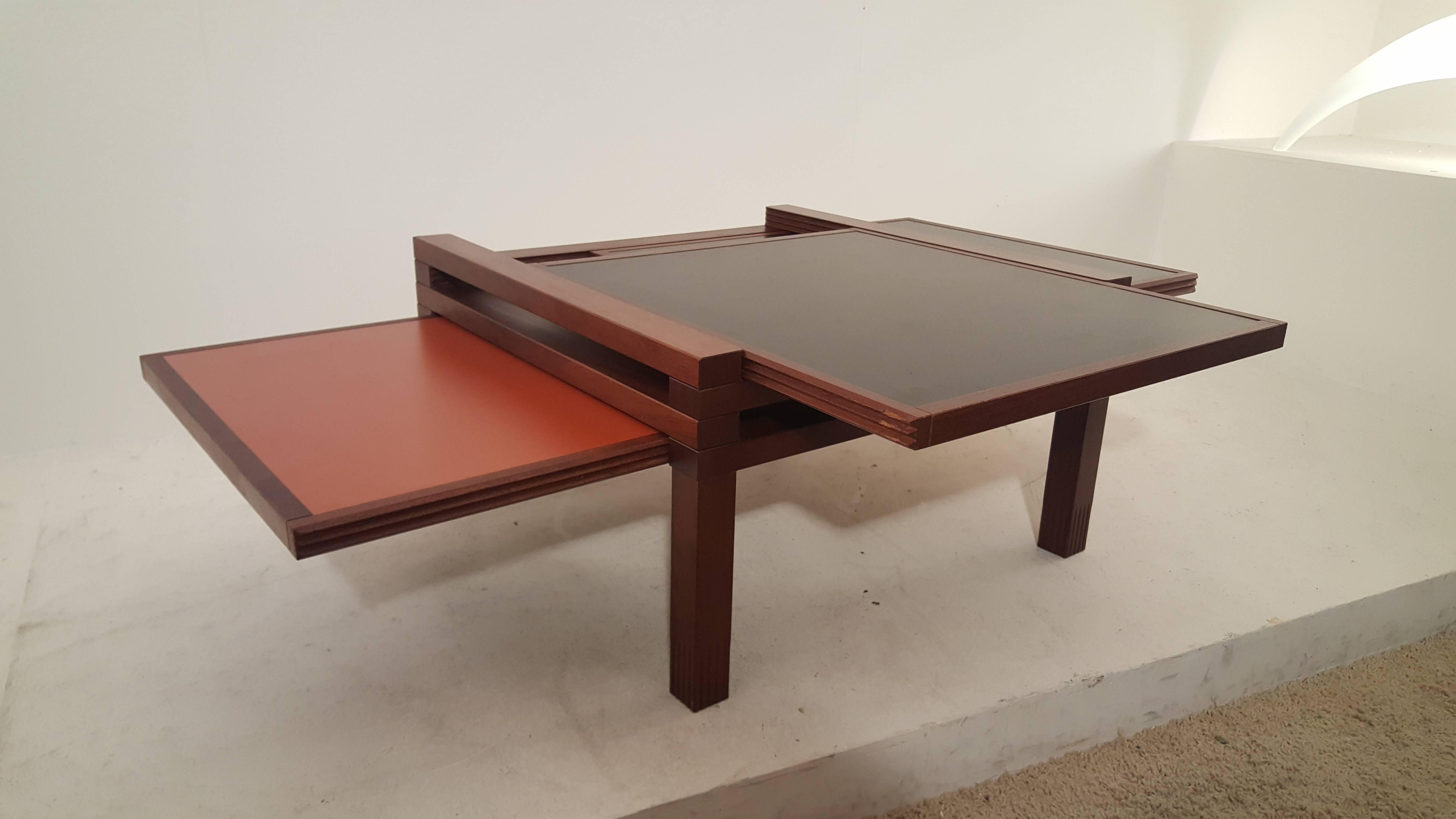 Very good looking coffee table by Bernard Vuarnesson for Bellato. The table is made from Iroko wood with black and (old) orange laminated tops. This model has a total of four tops/drawers that can be positioned in different ways. A dynamic table