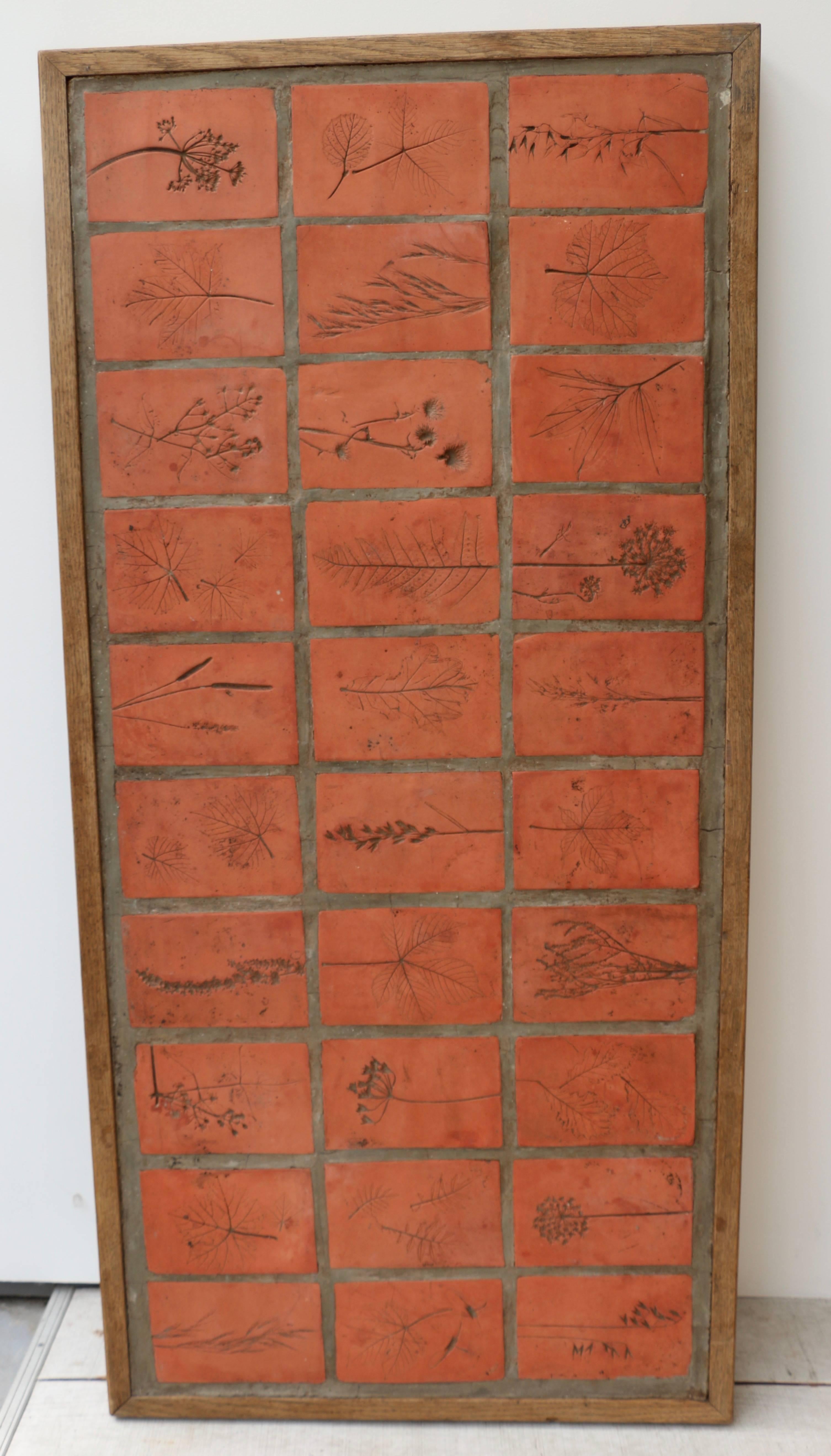 1963, Roger Capron, large panel in terracotta and oak from the herbarium series. Tomettes are all decorated with foliage and flowers.