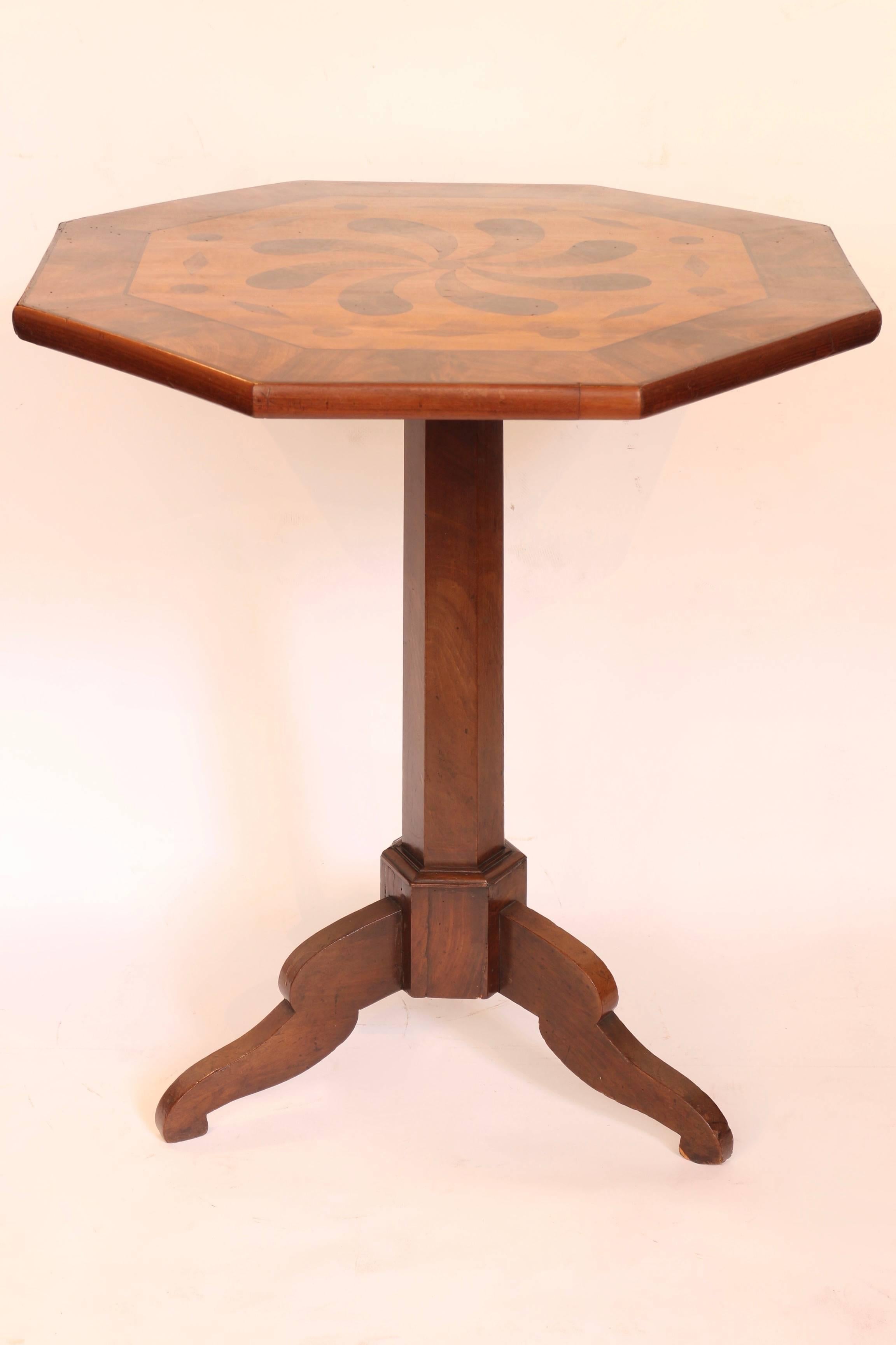 Mahogany tilt-top table with inlaid decoration on the top.
  