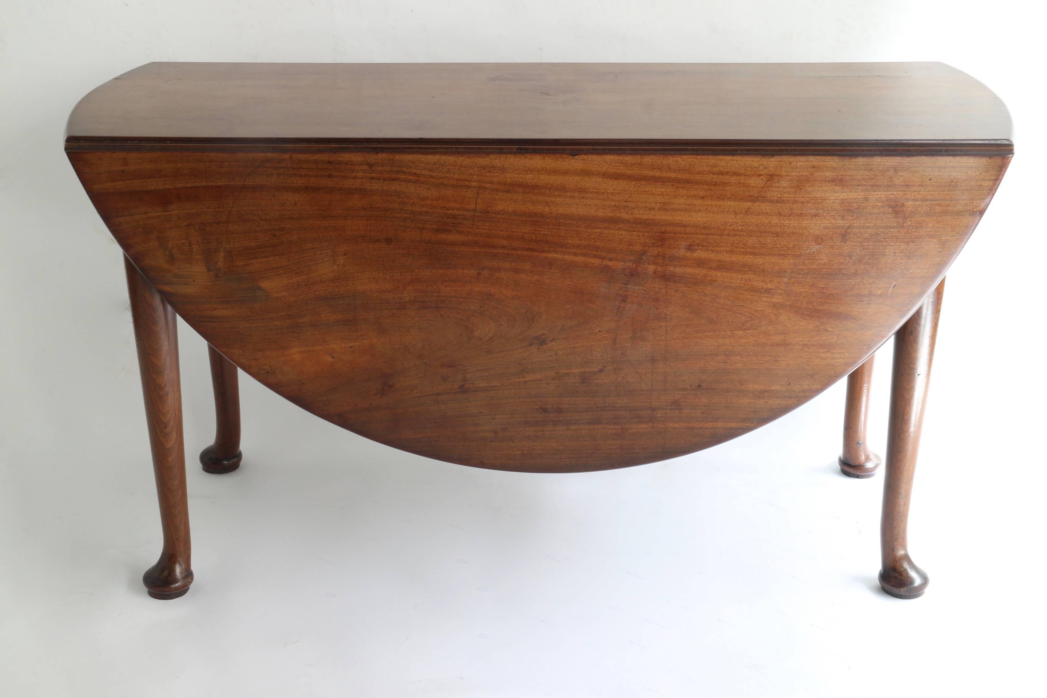 Early 18th century Queen Anne oval drop-leaf table in Cuban mahogany
Original beautiful wax patina
Very stable and comfortable to sit on with six people.