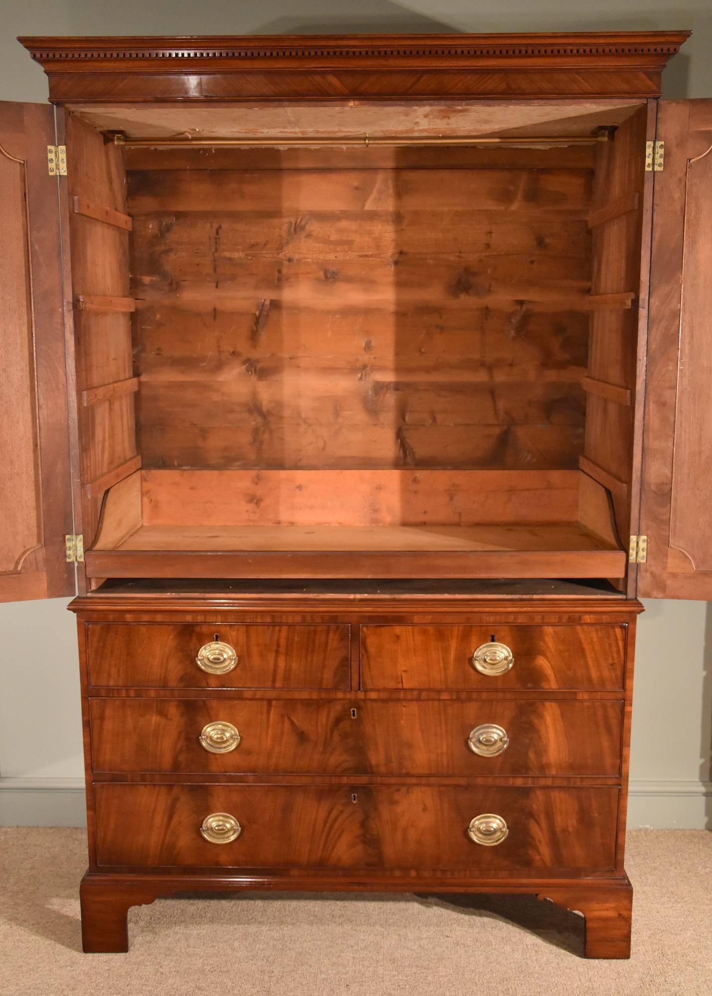 George III mahogany linen press with oval flamed panels and quarter veneered doors all over. Two short and three long drawers.

Dimensions:
Height 76