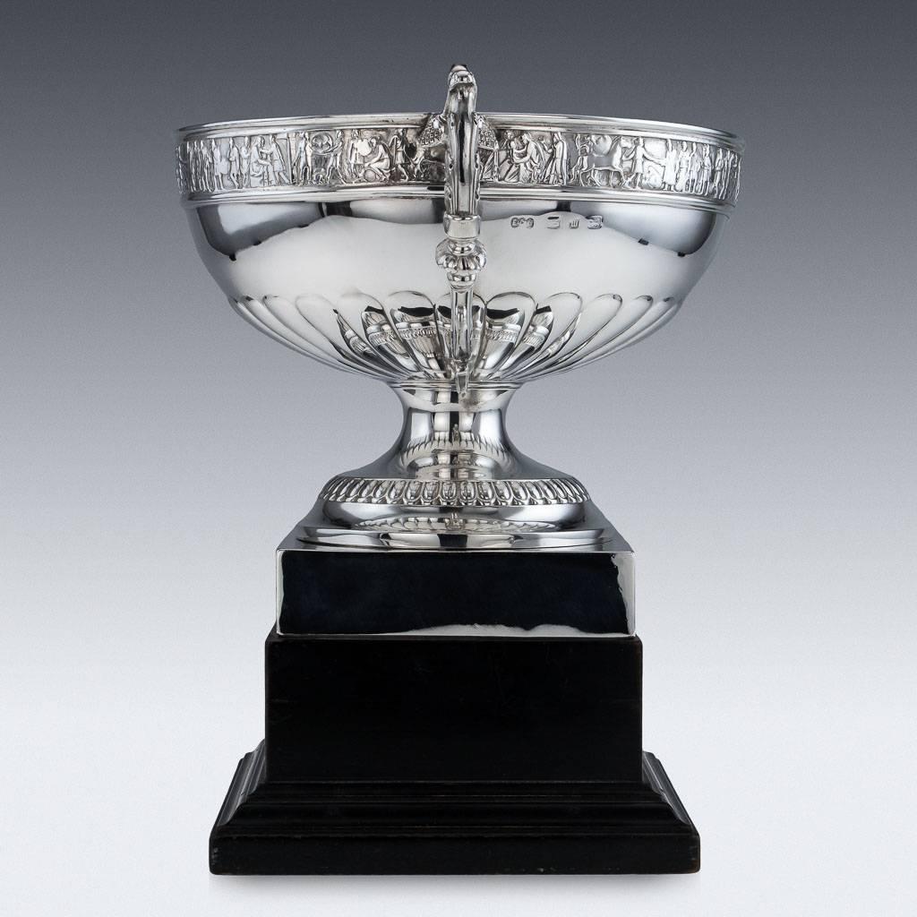Antique 19th century Victorian neoclassical style solid silver bowl, raised on a circular foot, mounted on a square base, top rim applied with vast frieze depicting classical figures, leaf embellished cast scroll handles. Presented on an ebonized