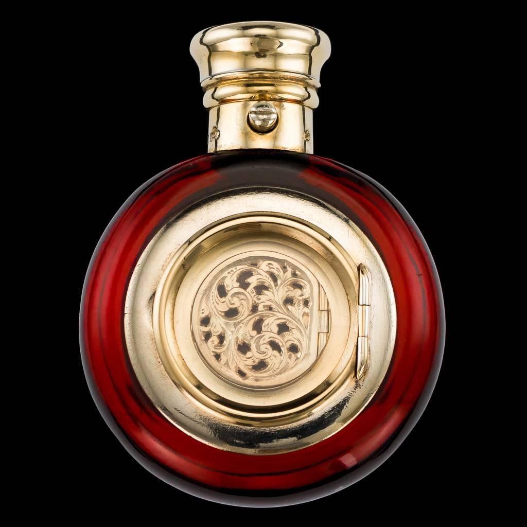 Antique 19th Century rare Victorian solid silver gilt & red cranberry glass scent bottle of round form with hinged top flip lid, combined with a vinaigrette containing a finely pierced grill and pill box. Hallmarked english silver (925 Standard),