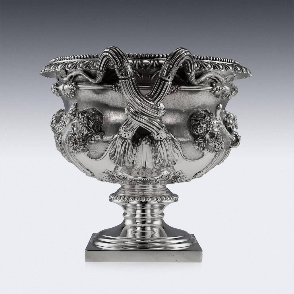 Antique 20th century Edwardian exceptionally rare solid silver warwick vase, of typical form on square base, with pedestal stem and acanthus at base of bowl, the sides applied with classical heads and lions pelts, with two entwining vine handles, an