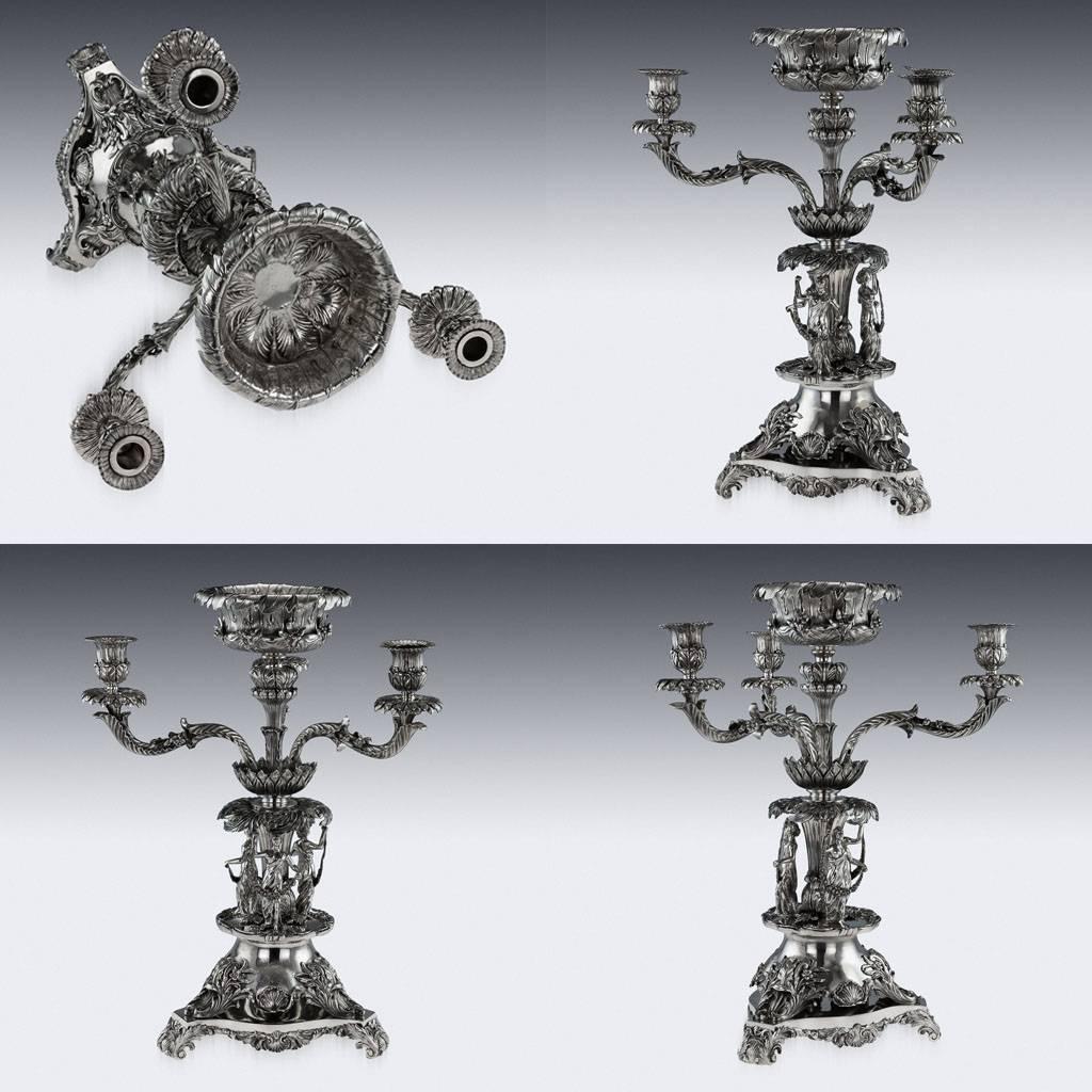 Antique 19th century early Victorian impressively large and magnificent cast candelabra centrepiece, the shaped base on three acanthus and shell feet, applied with an impressive coat of arms. The central round stand applied with three maidens each