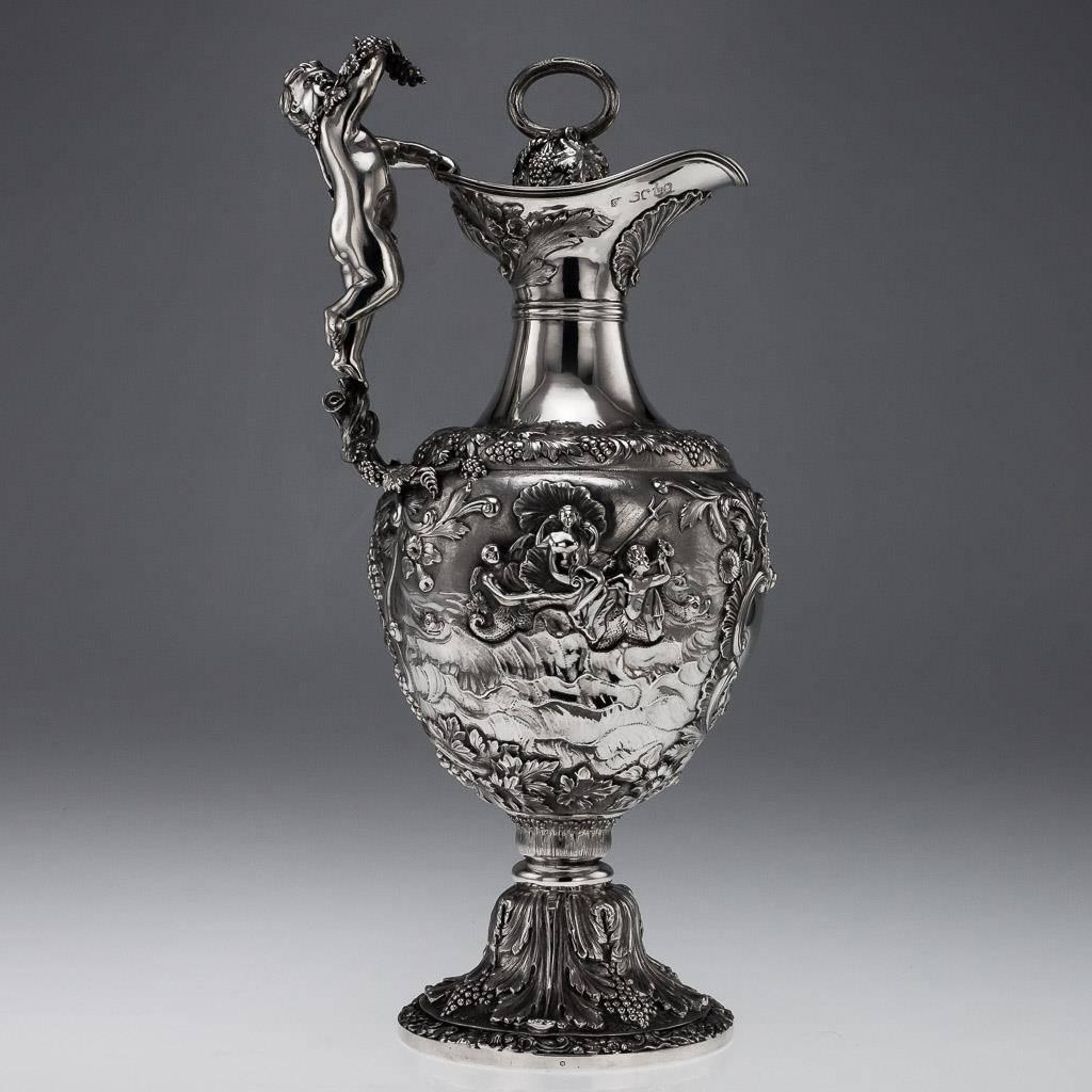 Antique 19th century rare and exceptional Regency solid silver figural wine ewer, extremely large and decorative, the tall baluster body profusely resting on a domed foot set with a turned wooden base, chased and embossed with acanthus leaves,