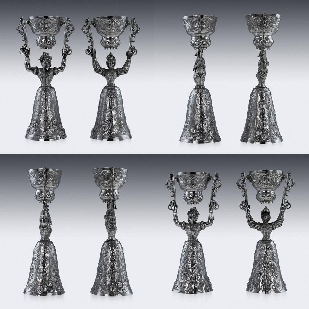 Antique 19th century German solid silver pair of wager / marriage cups, the cups design inspired by the early 16th century pieces, the female and male figures supporting over their head a domed smaller swivelling cup and the lower cup chased with
