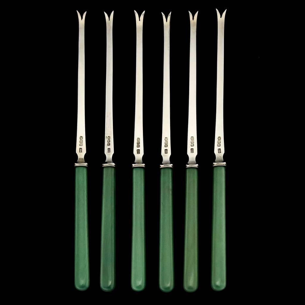 Antique 20th century rare solid silver set of six Lobster picks, of typical form with two pronged pick, used to extract meat from joints, legs, claws and other small parts of a lobster, each handle is fitted with a carved green stained handles. The