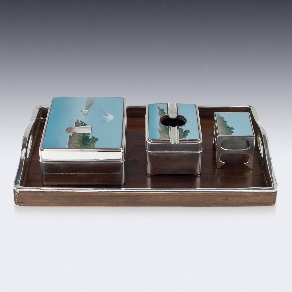 Antique early 20th century Japanese Meiji period solid silver and enamel four-piece smoking set, consisting of a cigarette box and ashtray box with removable lids, match case on four feet and accompanied with a tray. The tops are decorated with
