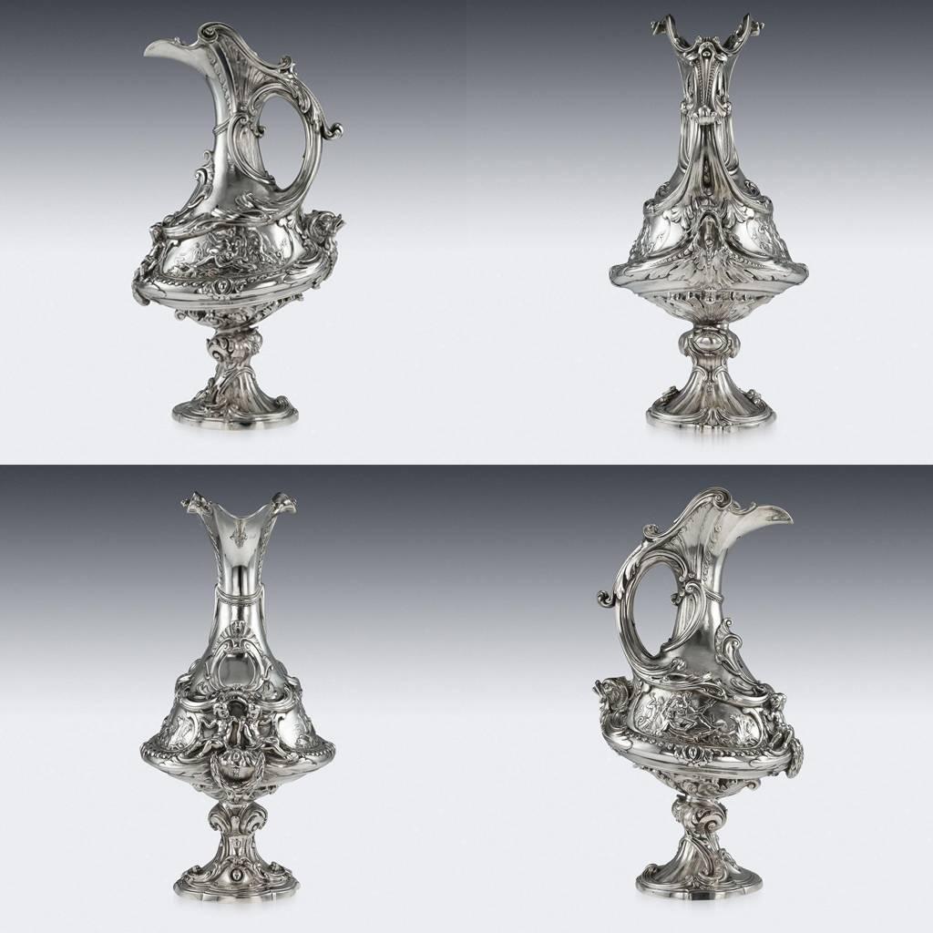 Antique 19th century exceptional Victorian solid silver figural wine ewer, extremely large and decorative, the tall body profusely decorated, resting on a shaped rococo foot, chased and embossed with acanthus leaves, scrolls and shells, Each side