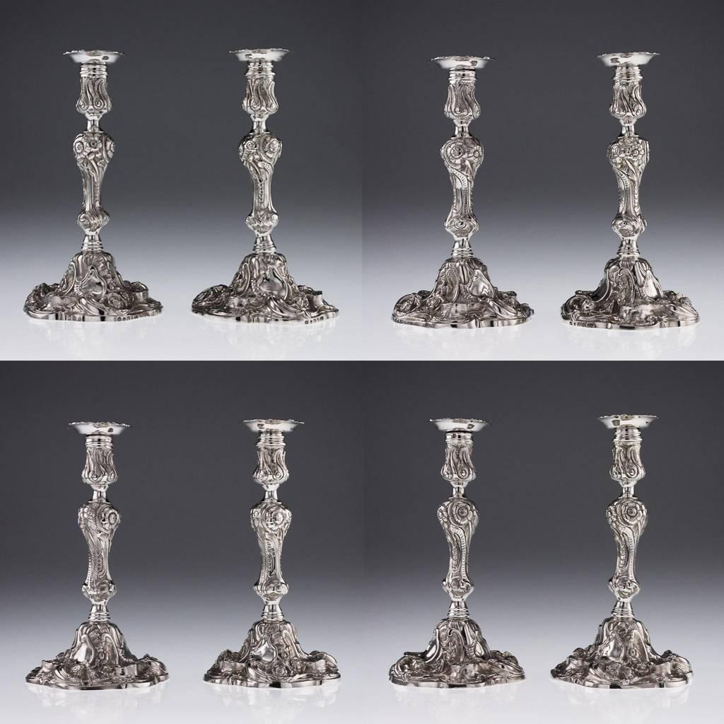 Antique 19th century rare pair of Georgian solid silver cast candlesticks, each on a shaped circular base cast with scrolls, flowers and waterfalls in very high relief, the conforming knopped baluster stem also embellished with flowers and scrolls,