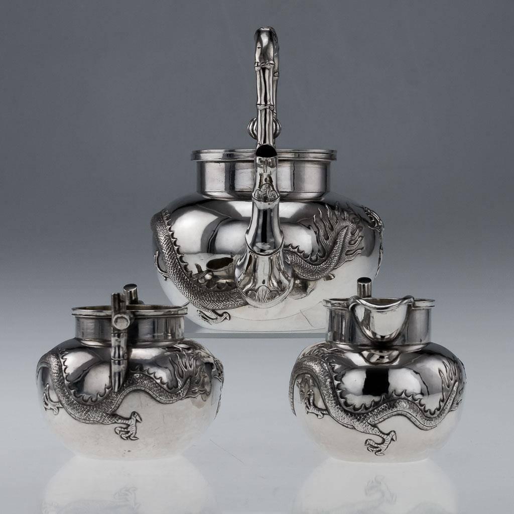 Antique late-19th century Chinese export solid silver three-piece tea set, comprising of teapot, sugar bowl and milk jug, each spherical body embossed with dragons in relief, cast spout modelled as a bamboo branch, handles also shaped like bamboo