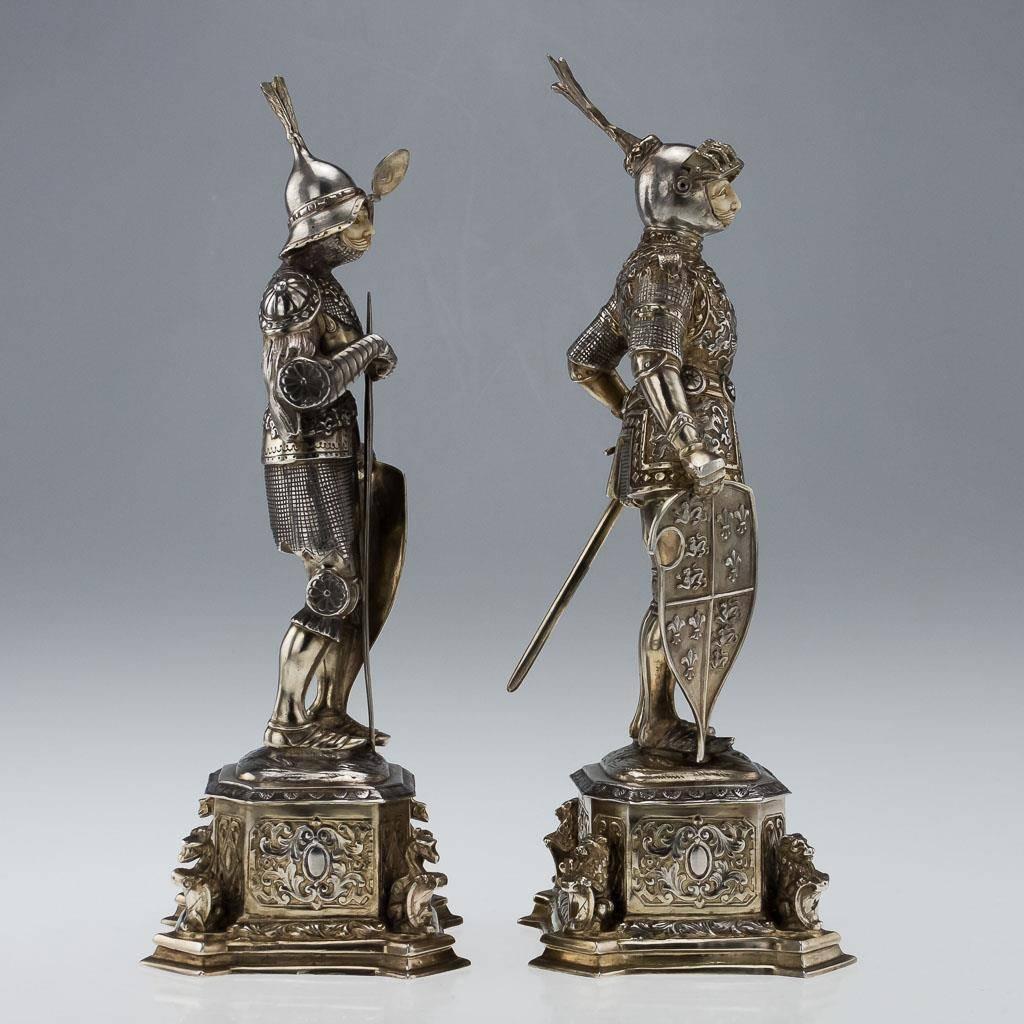 Antique early-20th century pair of large and fine German solid silver figures, each parcel-gilt and modelled as a knight in full suits of armour, carved face beneath a hinged visor, one sporting a sword and the other an axe, both holding a shield