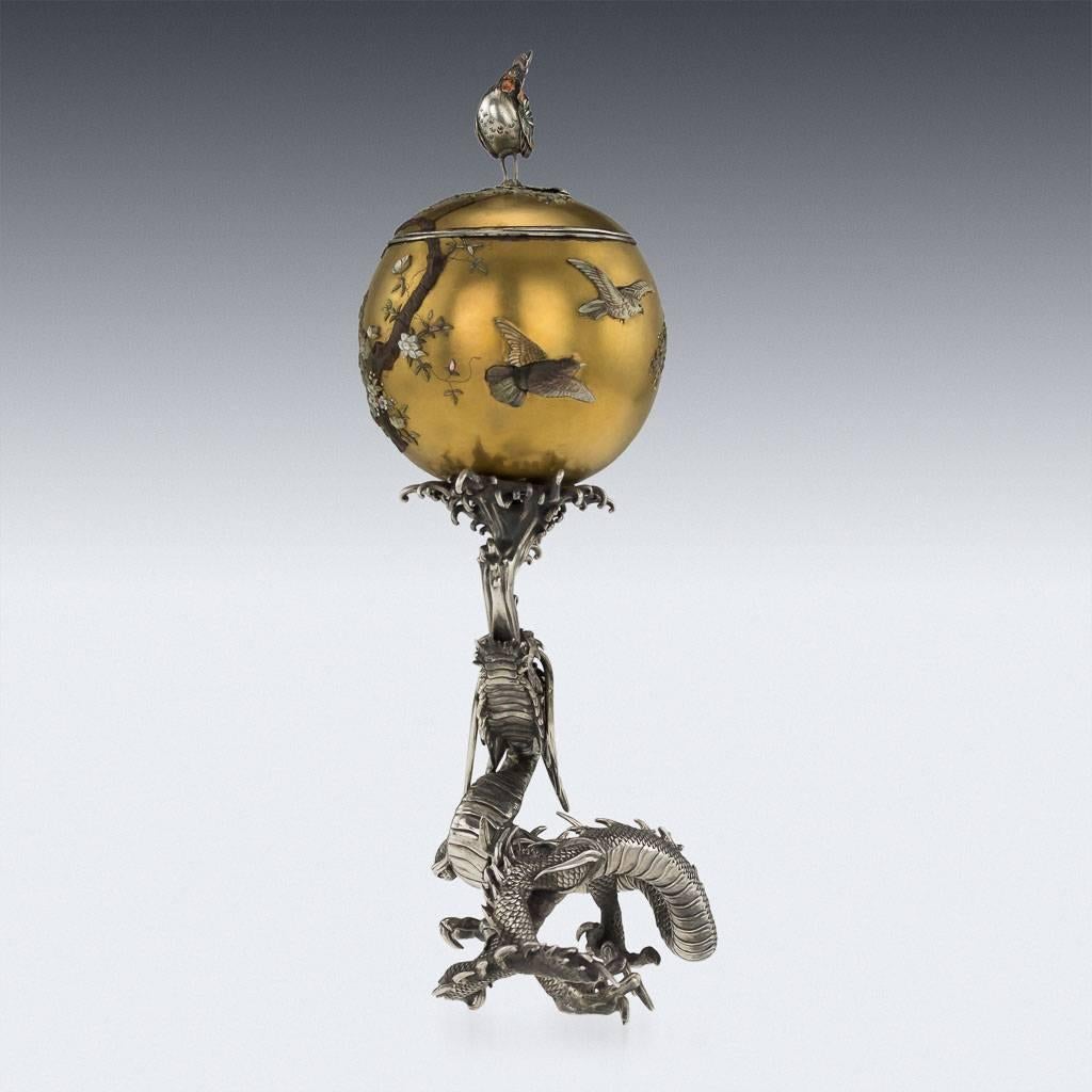 Antique 19th century Japanese Meiji period solid silver and shibayama model of a dragon. Cast and carved as a serpentine water dragon, spiked body, mouth open with a stylized wave spray supporting a gold lacquered shibayama ball mounted with an