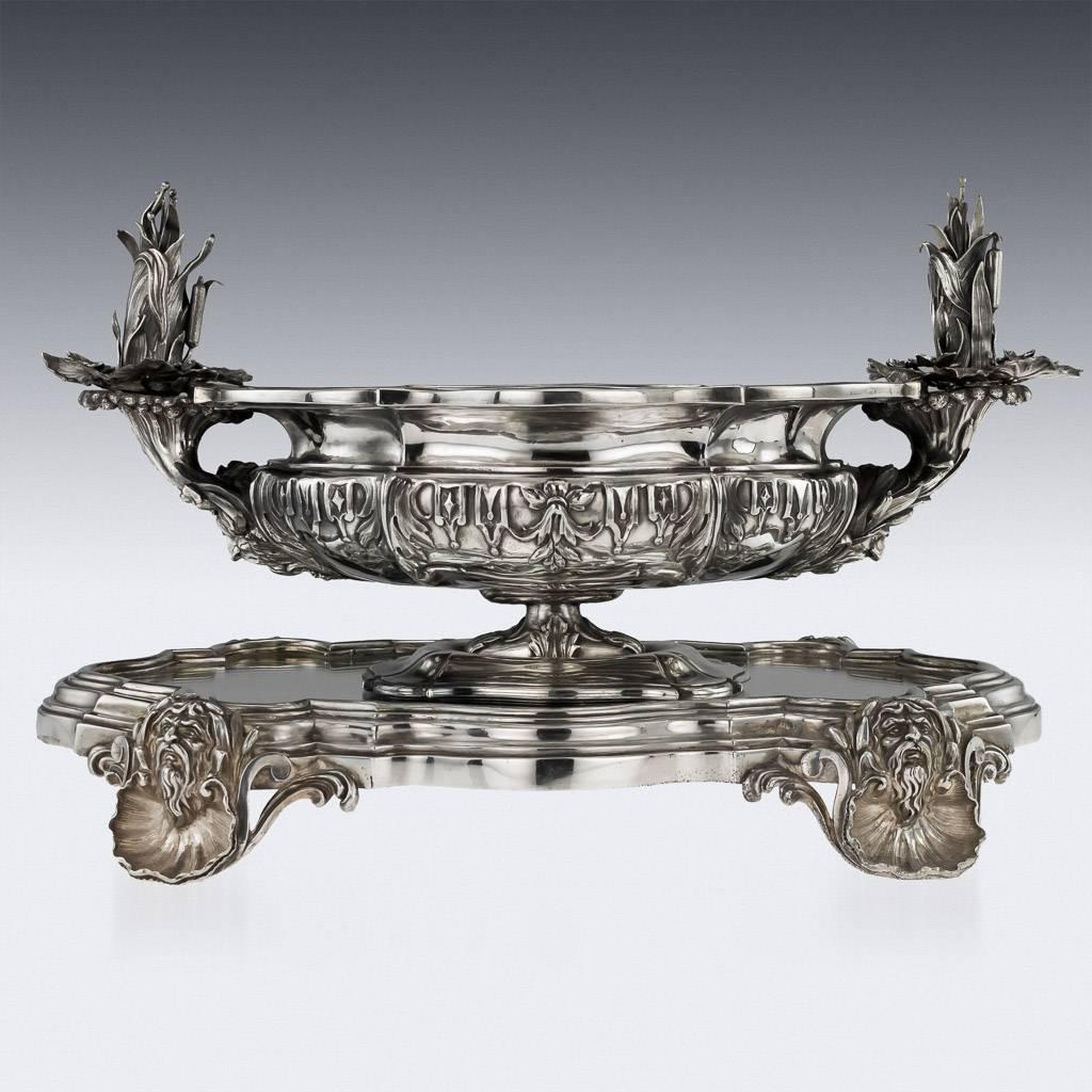 Antique 19th century Georgian solid silver stunning and large centrepiece bowl on a mirror plateau, both of cartooche form, the stand raised on beautifully modelled shell and Neptune mask feet, the bowl chased with floral motifs, the sides