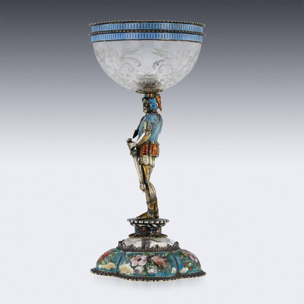 Antique 19th century Austrian rock crystal, solid silver-gilt and enamelled figural cup, the rock crystal cup profusely carved with scrolling foliage in the Renaissance style, the silver mounts richly gilt and enamelled with panels depicting scrolls