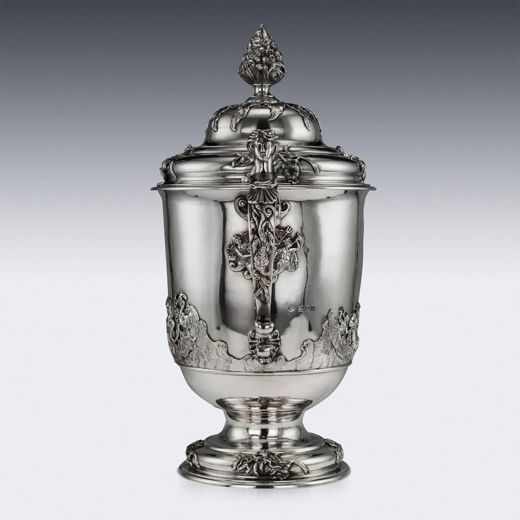 Antique 20th century Edwardian solid silver monumental cup and cover, campana form, particularly large and heavy gauge, applied with foliage, cast scroll handles with realistically modelled maidens heads thumbpieces, both sides decorated with