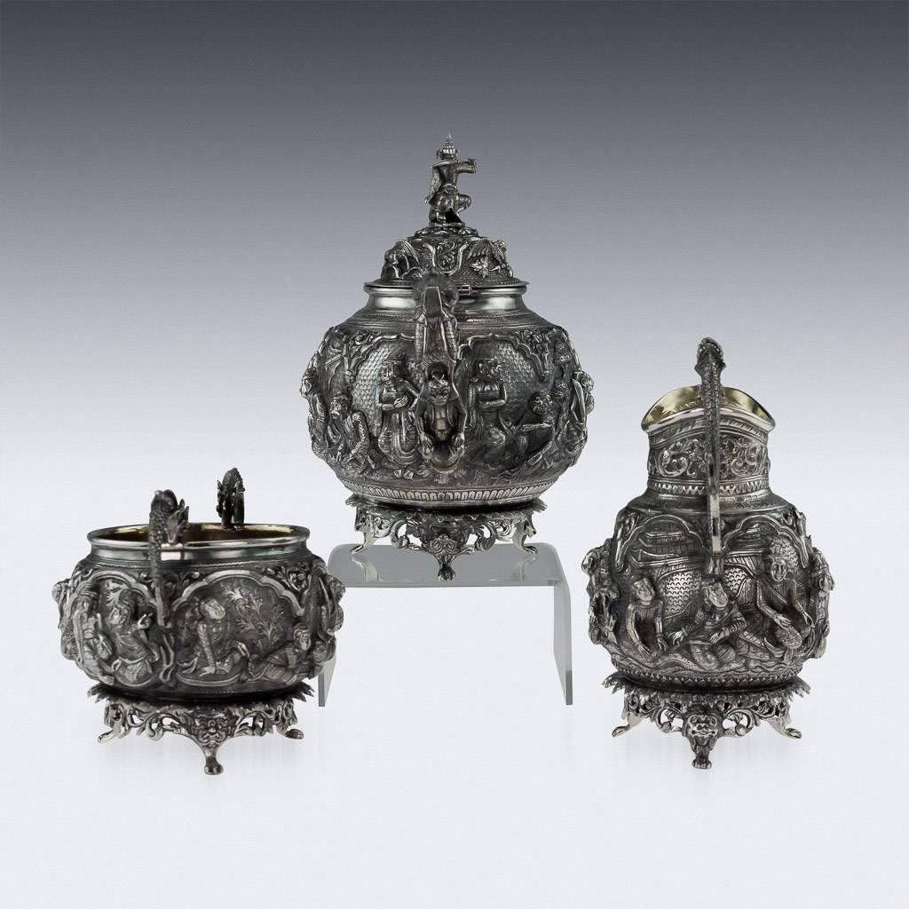 Antique early 20th century rare and magnificent Burmese, Myanmar solid silver parcel gilt three-piece tea set on tray, comprising of teapot, sugar bowl, cream jug, each piece is highly-decorative, chased and repoussed with various scenes from